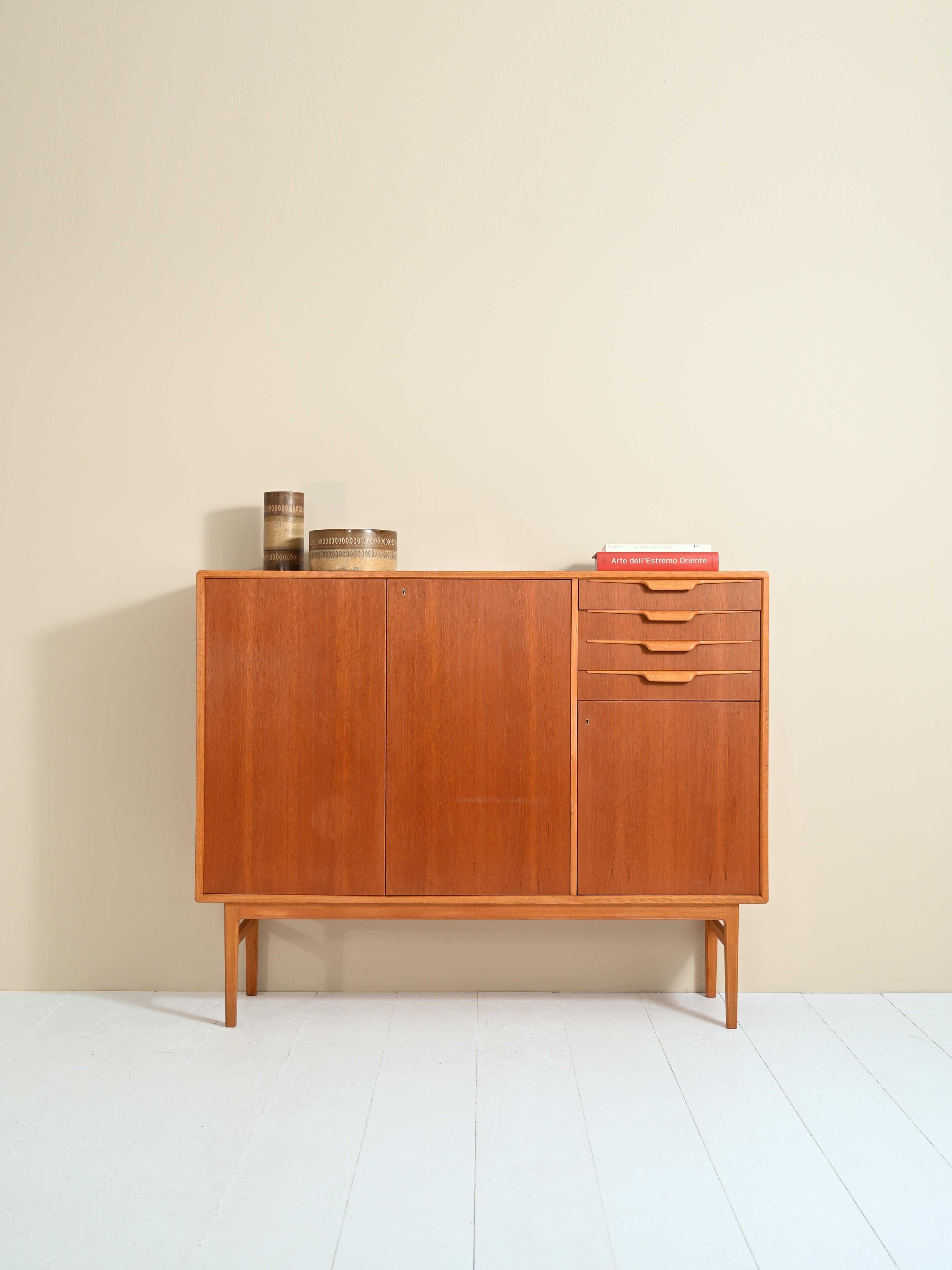 Sideboard designed by B. Fridhagen for Bodafors in the 1960s.

A capacious piece of furniture with a peculiar appearance. On one side is a storage compartment with hinged doors and on the other are four drawers and a small space also closed by a