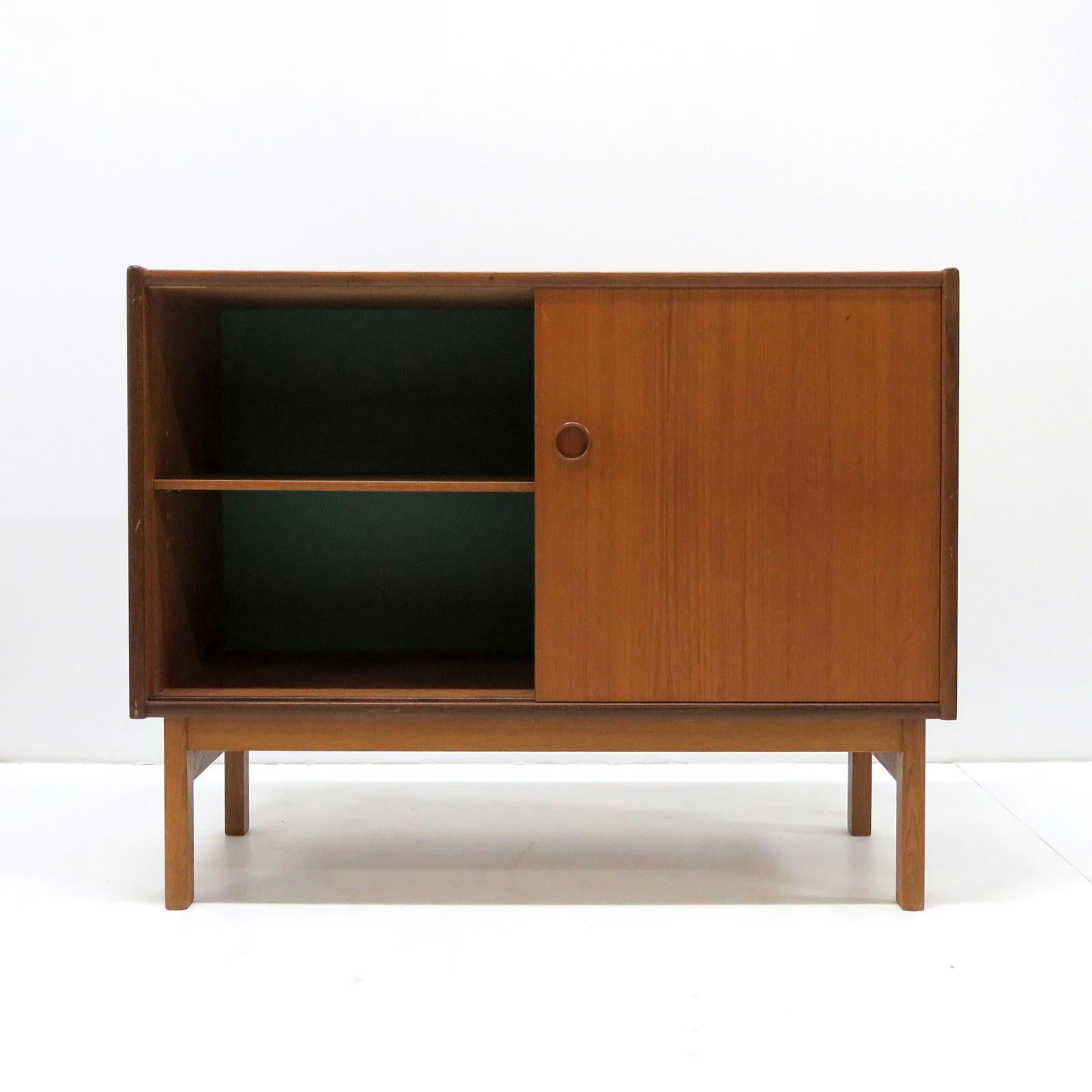 wonderful small-scale 1960s Danish sideboards/dressers in teak on an oak frame, with one adjustable shelf behind two sliding doors, the inside of the back wall is teal colored. Priced individually.