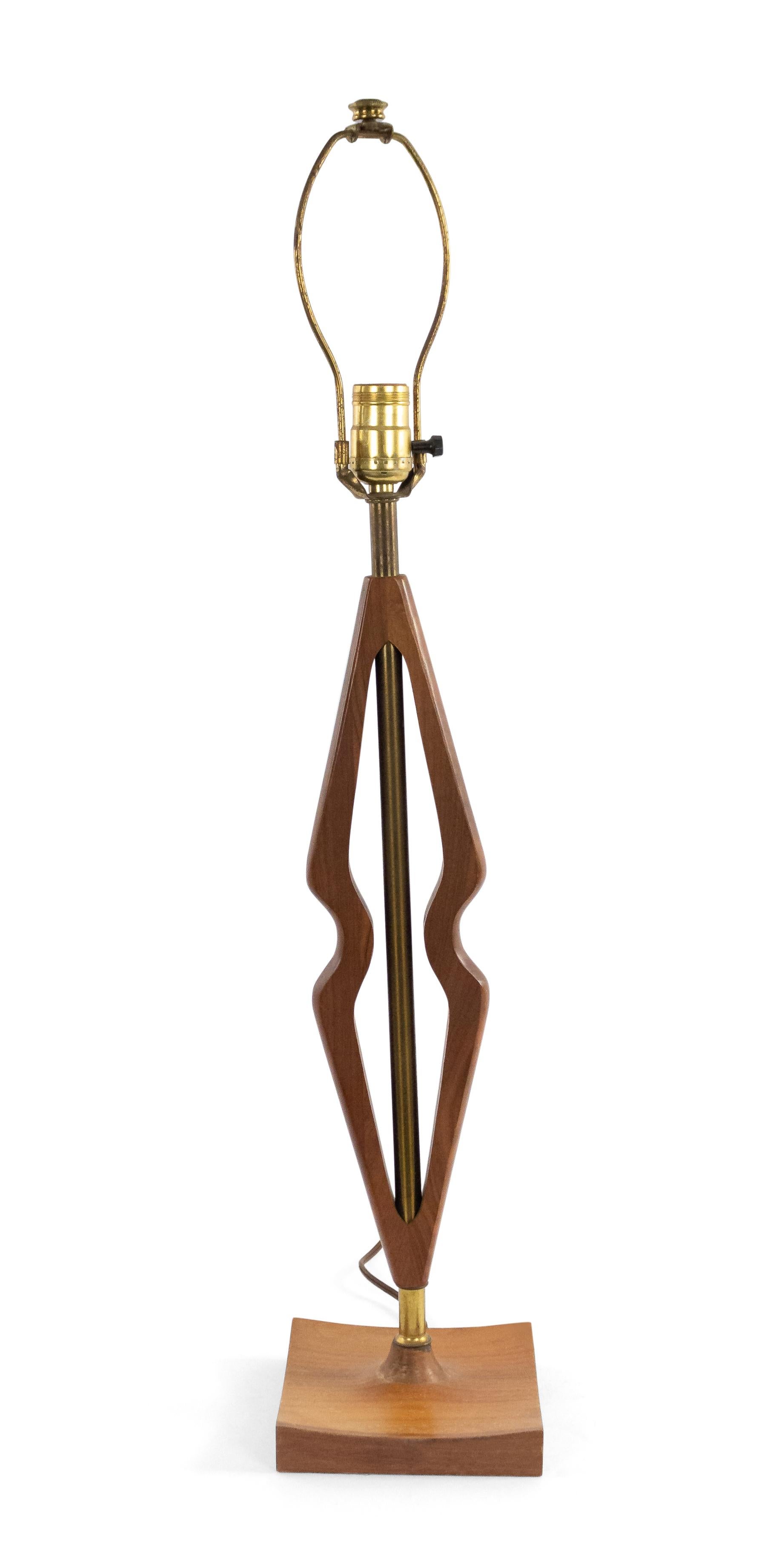 Scandinavian Post-War design teak table lamp with 2 shaped forms centering a brass tube resting on a slight concave square base.