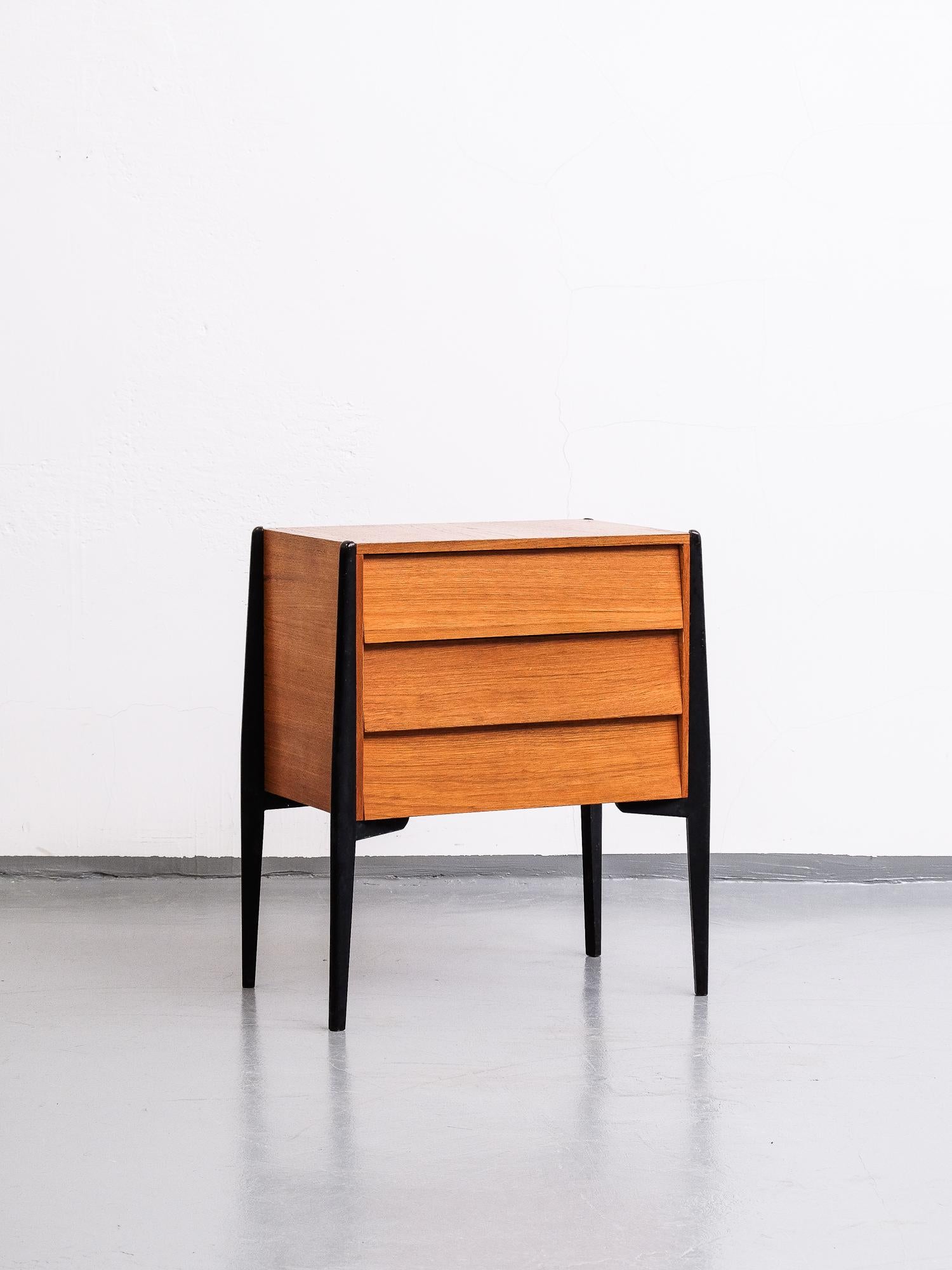 Swedish modern mid-century three drawer chest/night stand in beautiful teak and black painted legs. In excellent original condition.
