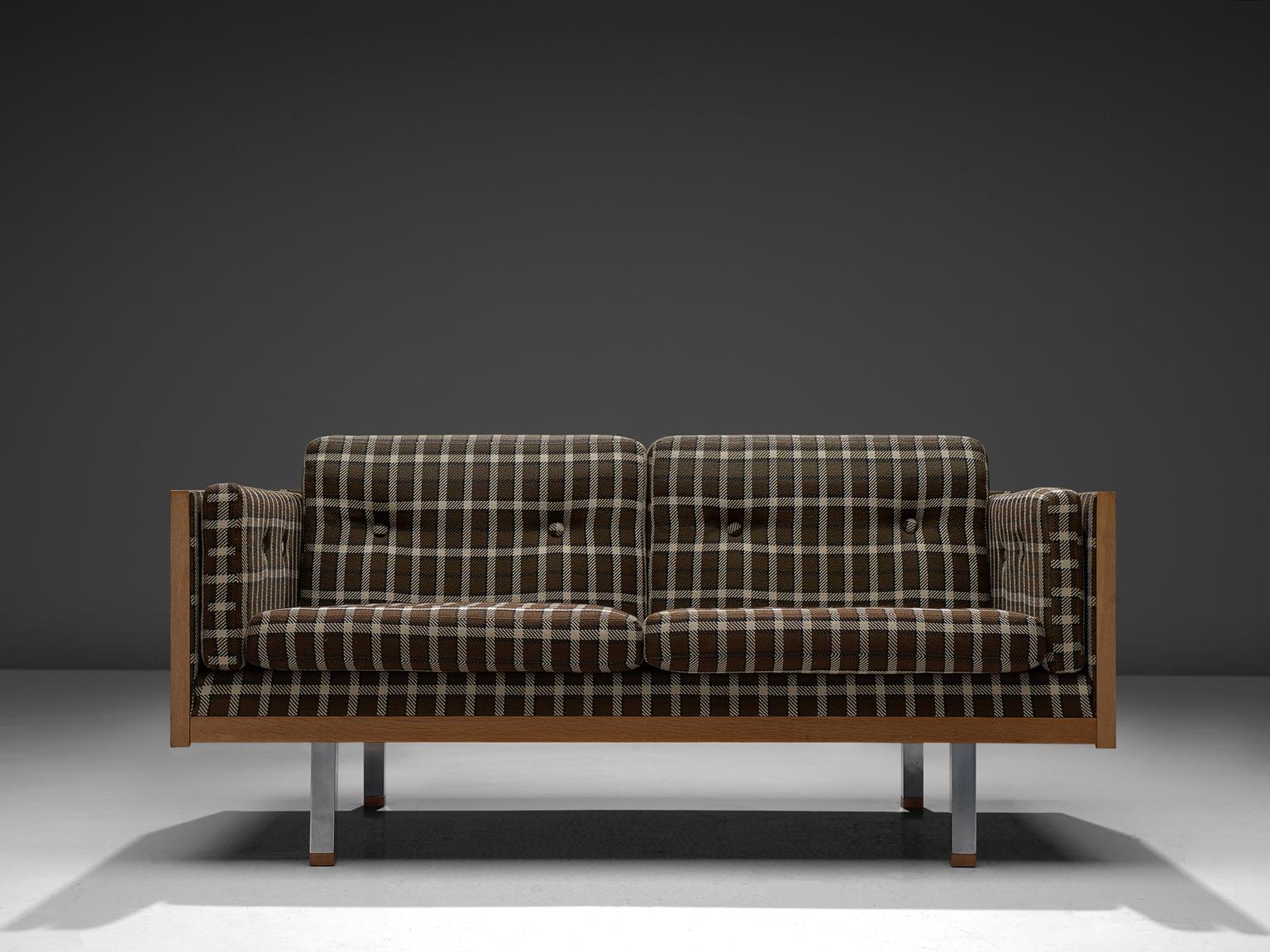 Jydsk Mobelvaerk, two-seat sofa, in oak, metal and fabric, Denmark, 1960s. 

Scandinavian two-seat sofa. The frame consist of oak with cubic metal legs, which provide an open look to the quite solid seating. All sides are covered with wood and