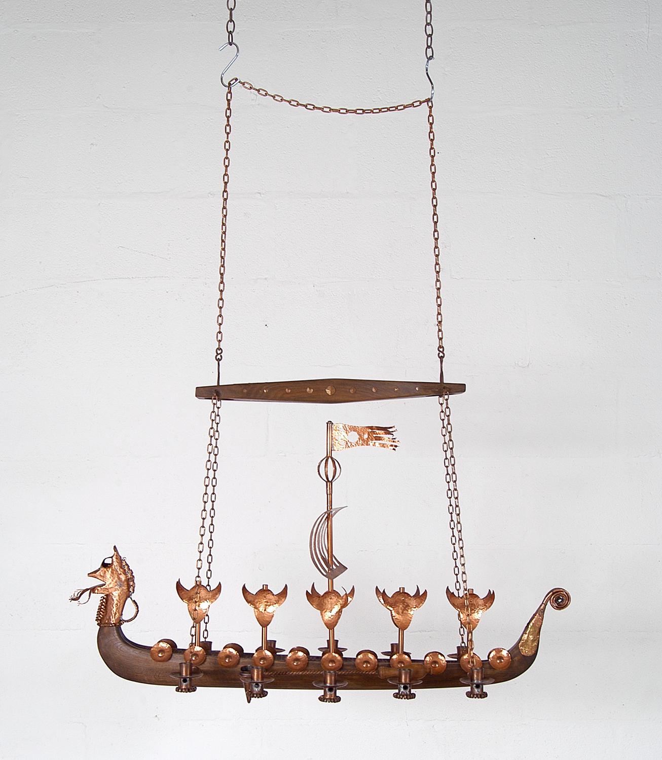 Very high quality copper and oak Danish Viking Ship Longboat candelabra in the form of a dragon, which makes an impressive centerpiece hanging above a smorgasbord dinner table!
The dragonhead, tail, shields, Viking helmets, sail and candleholders