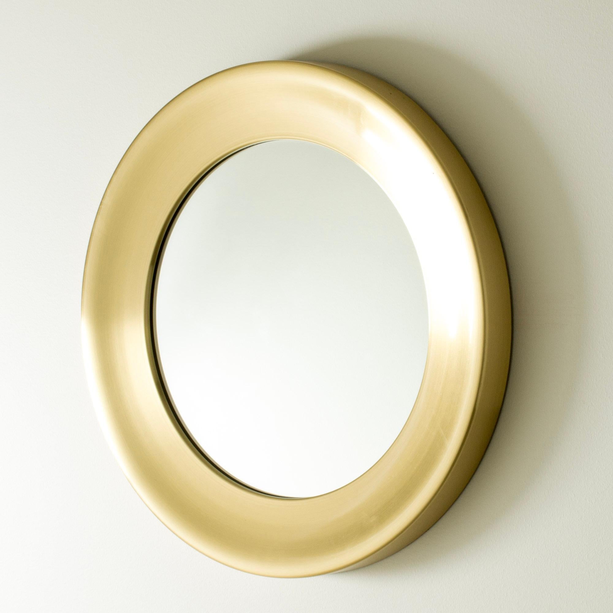 Grand miroir rond de Glasmäster i Markaryd, composé d'un large cadre en laiton. Elegant et décoratif.