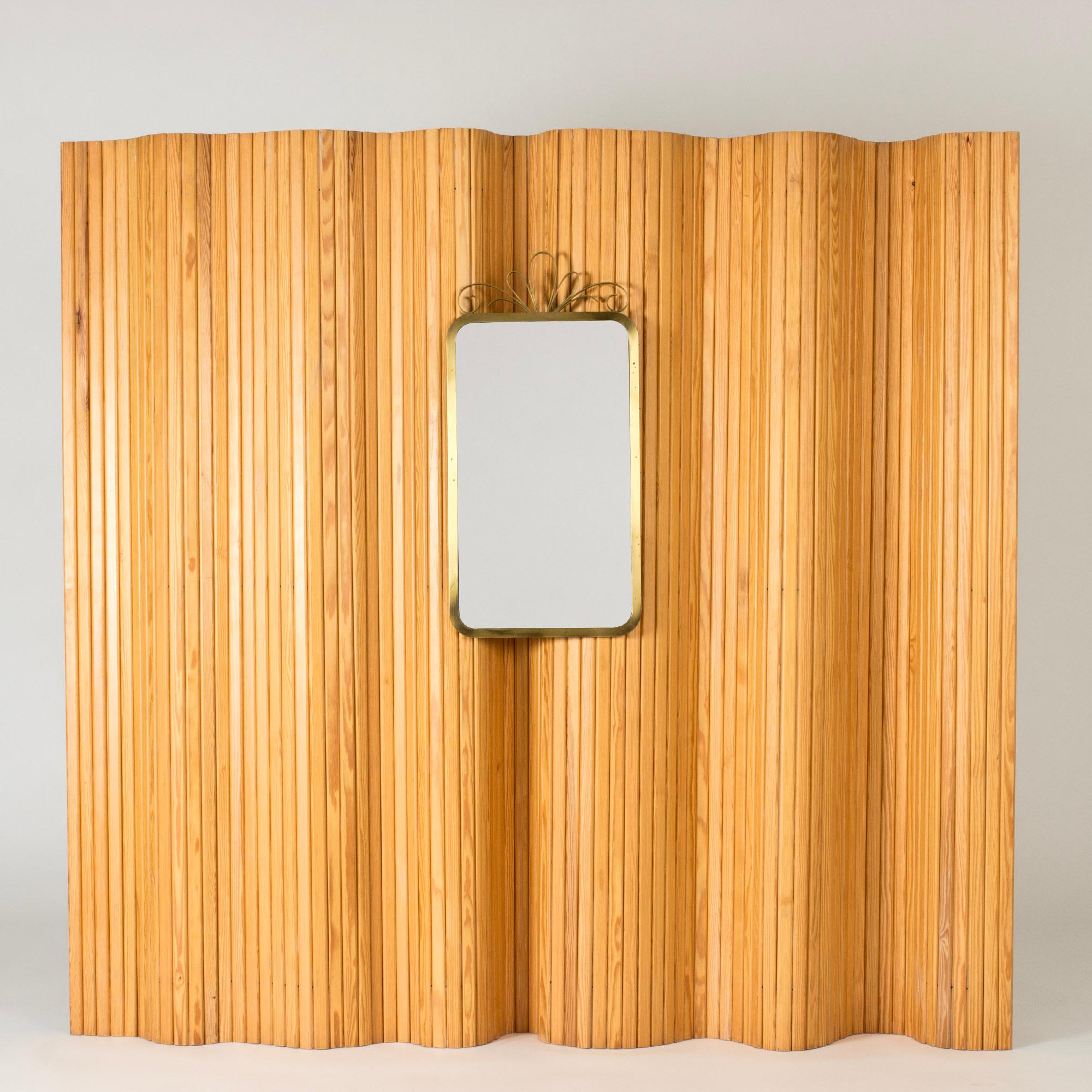 Elegant wall mirror from Ystad Metall, with a rounded corners brass frame. Decorative bow on top.