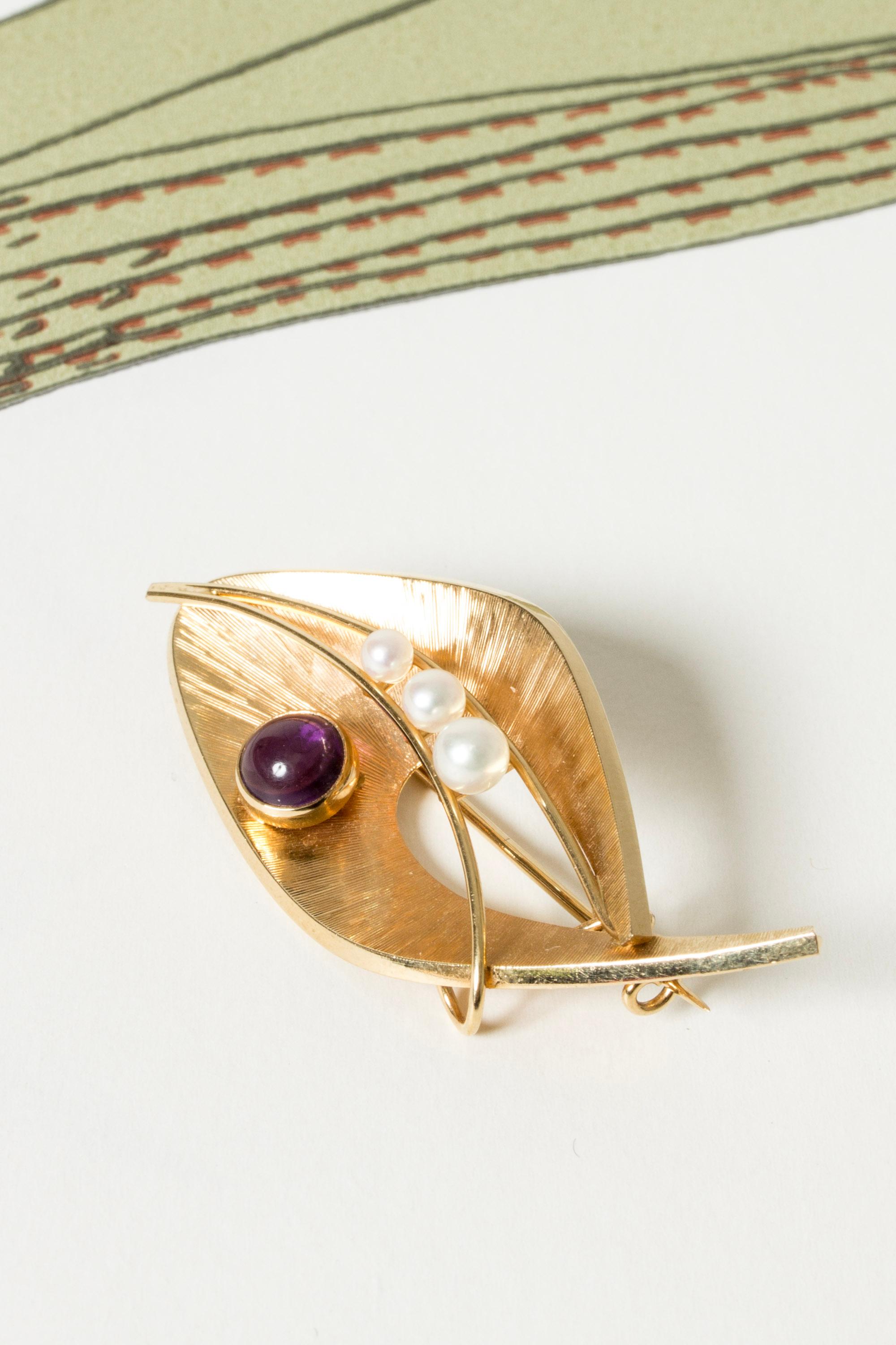 Swedish Modernist gold brooch in a sweet, organic design with nice details. Cabochon cut amethyst stone and a row of small pearls.

Maker: Guldsmedsateljé G B Nilsson, Sweden