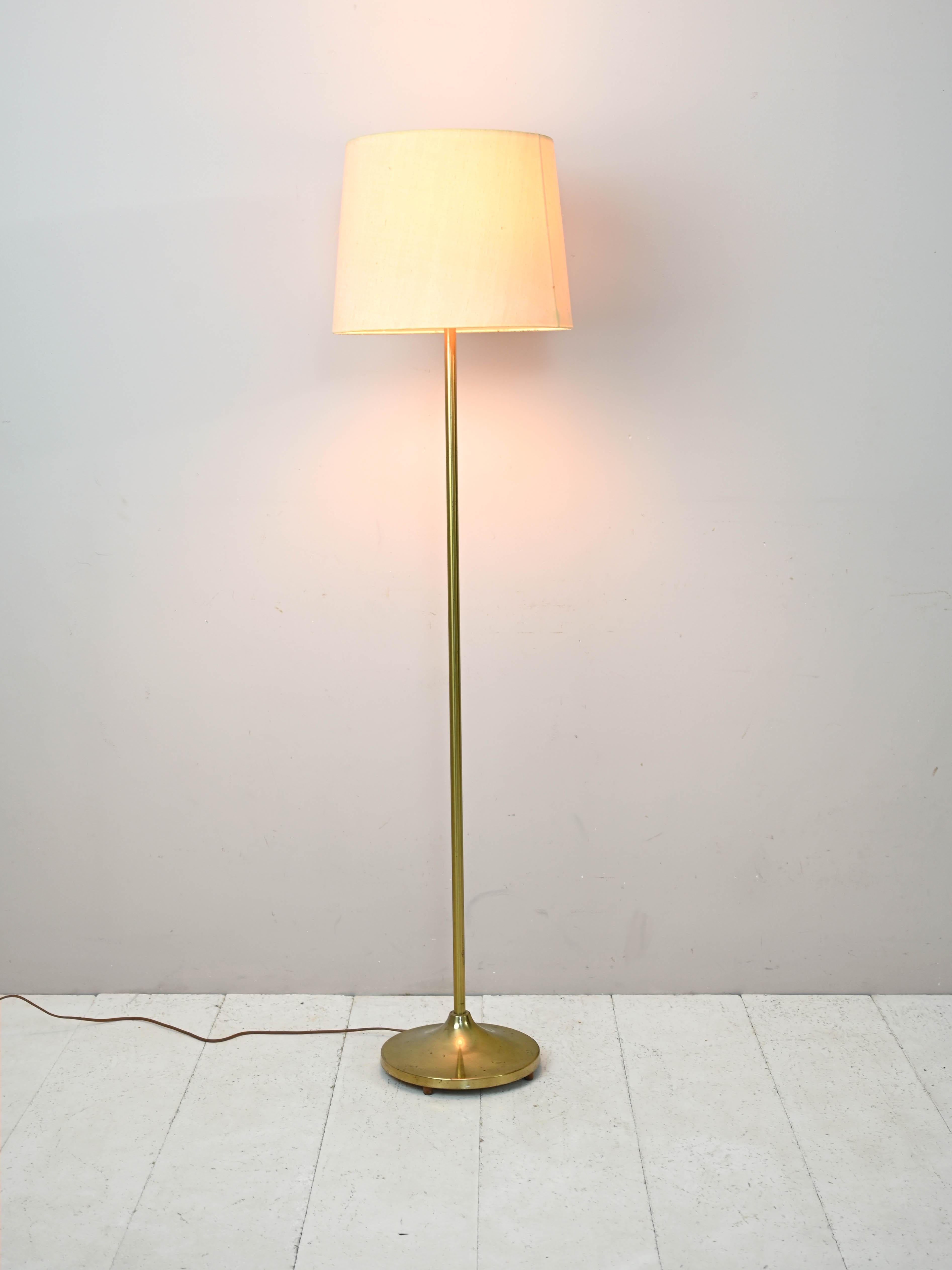1960s floor lamp with fabric shade.

This classically styled addition features a gilded metal frame and a cylindrical fabric shade.
Ideal for adding a retro touch to a contemporary styled room.

Good condition. May show some signs of aging.
