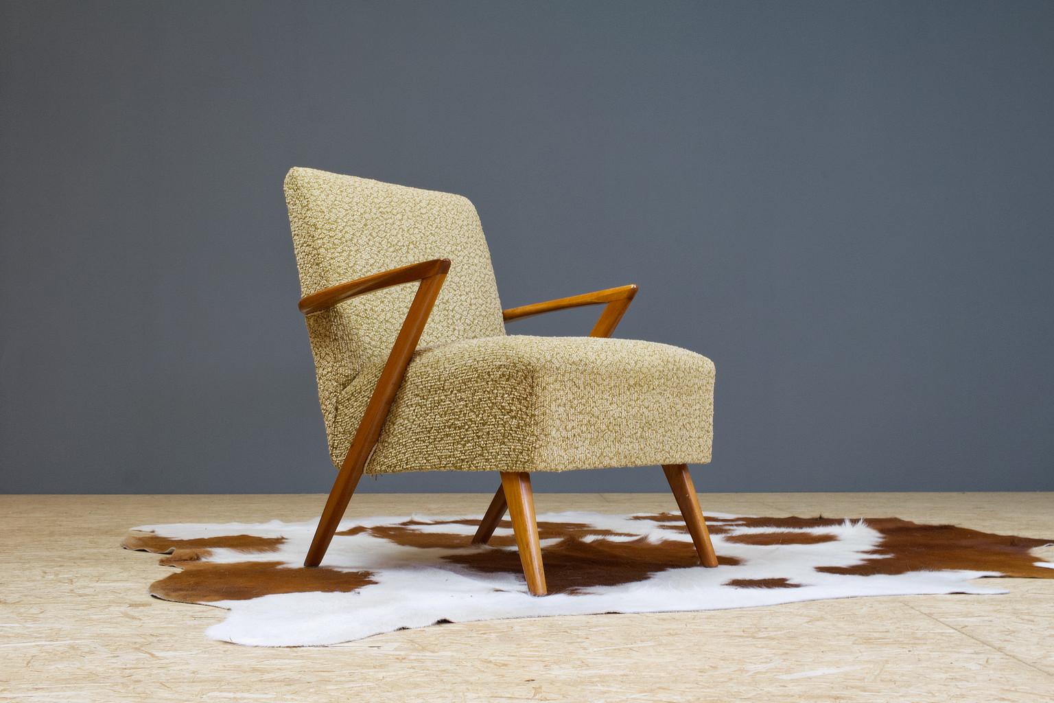 Modest yet with the sculptural armrest a very striking design. You'll see architectural threats of Kurt Olsen in this design, yet designer unknown. Original vintage Scandinavian Modern lounge chair in elm. Great sculptural angle in the elm wooden