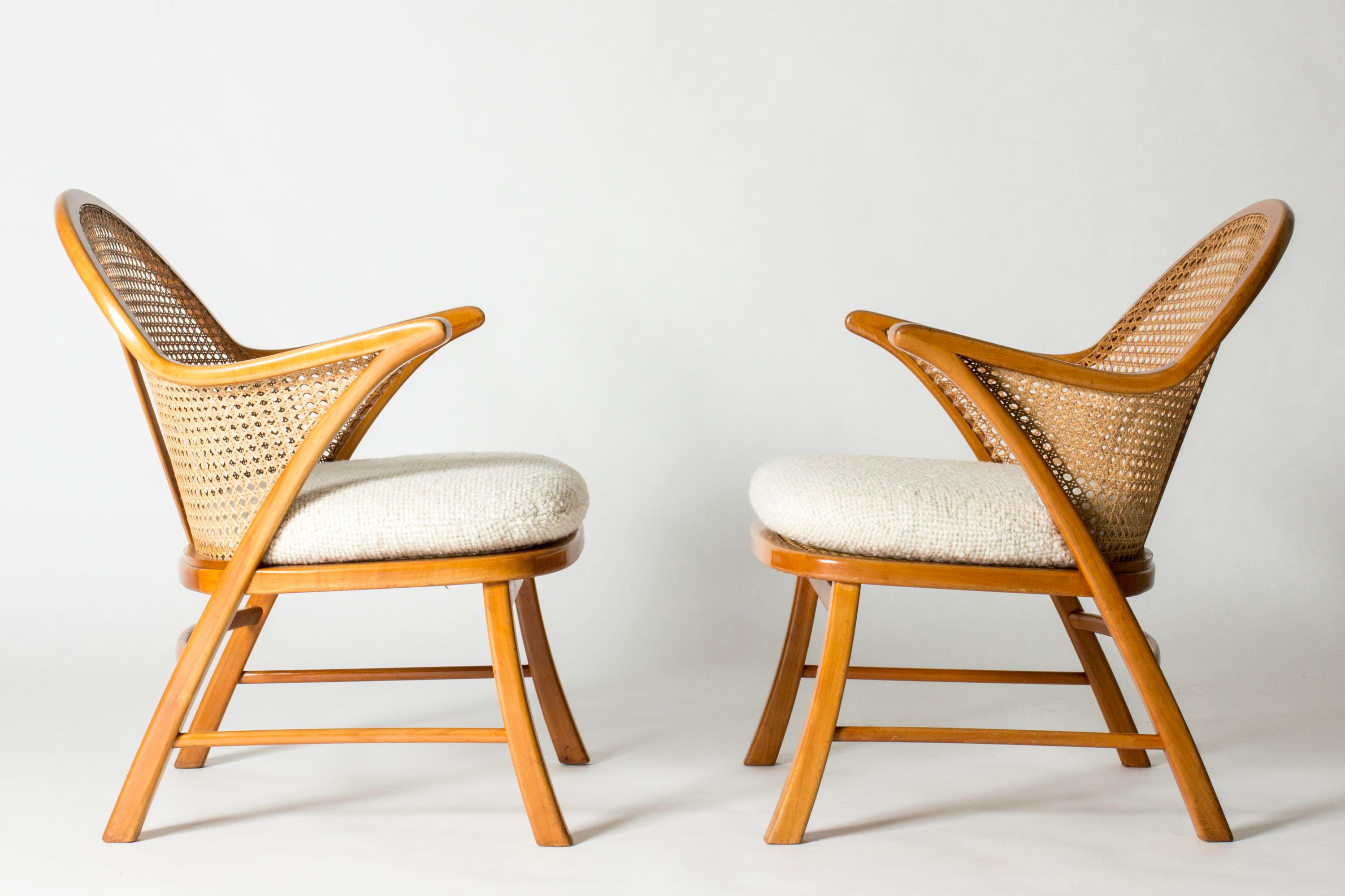 Pair of beautiful lounge chairs attributed to Frits Schlegel, in a neat and light design. Made from mahogany and very decorative rattan, puffy seats with white bouclé upholstery.