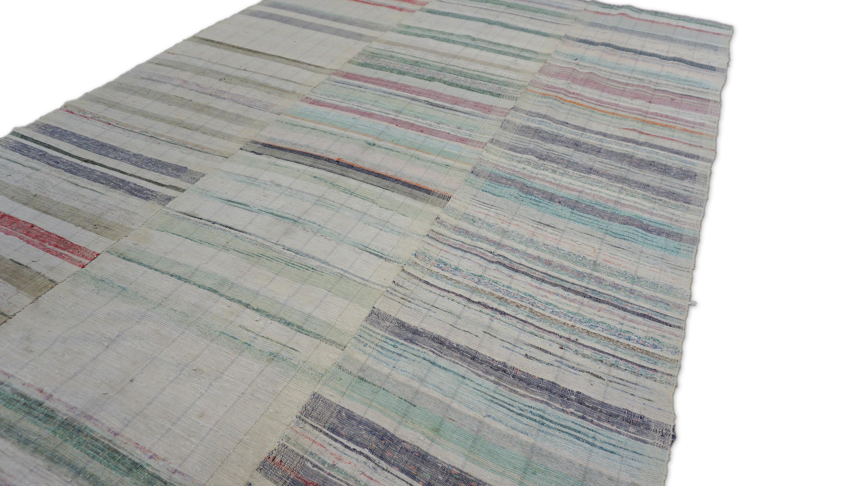 Dieses Flachgewebe aus handgewebter Wolle im Vintage-Stil zeigt ein charmantes Patchwork aus sanft verblichenen Streifen in zarten Pastelltönen. In drei verschiedenen vertikalen Bahnen gewebt, zeigt der Teppich einen handwerklich unregelmäßigen