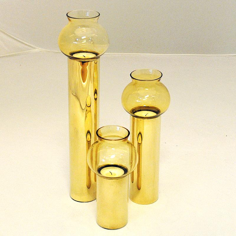 A lovely set of three Scandinavian brass cylinder candle holders from the 1960s. Three sizes. With oval shaped amber colored glass shades. Removable glasses - so the candle lights may also be used without the shades if preferred. For tea lights.