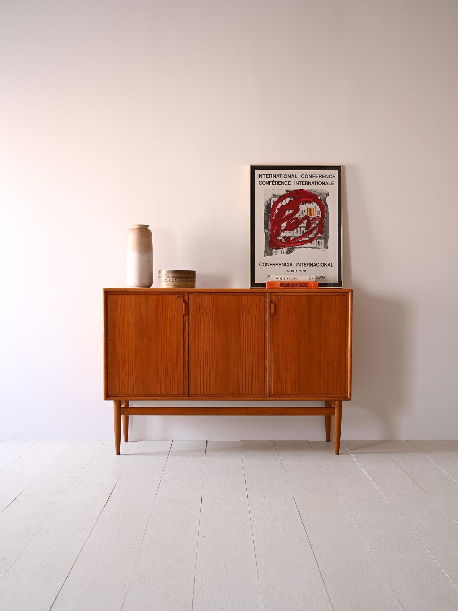 1960s sideboard of Nordic manufacture.
Simple and classic lines for this vintage sideboard with three hinged doors.
It consists internally of two separate compartments, one equipped with shelves and the other with two small drawers and a storage