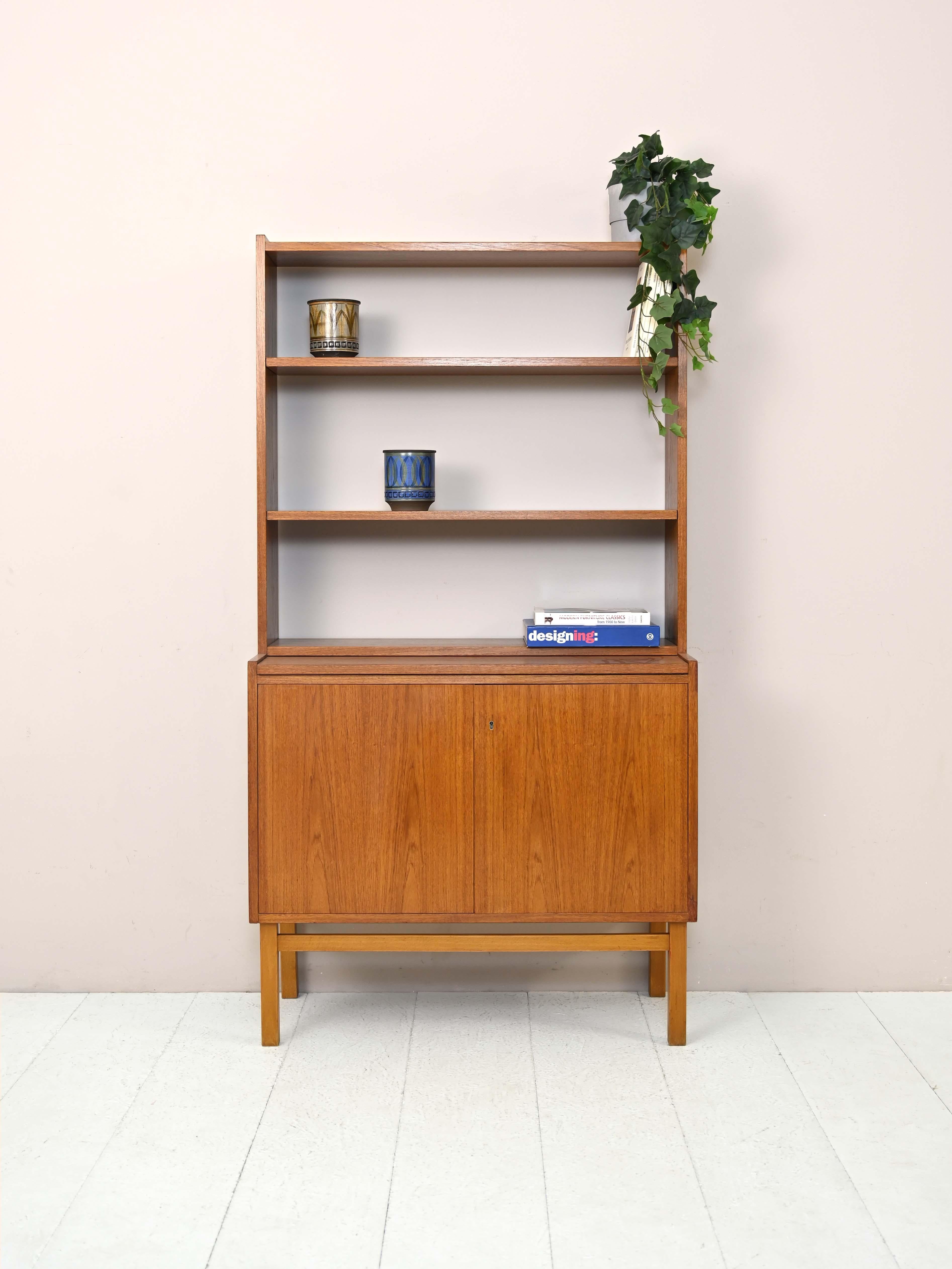Swedish modern antique 1960s bookcase.

A simple and functional piece of furniture consisting of a storage compartment with hinged doors and an adjustable-height shelving system.
This bookcase, thanks to its small size, can be placed in different