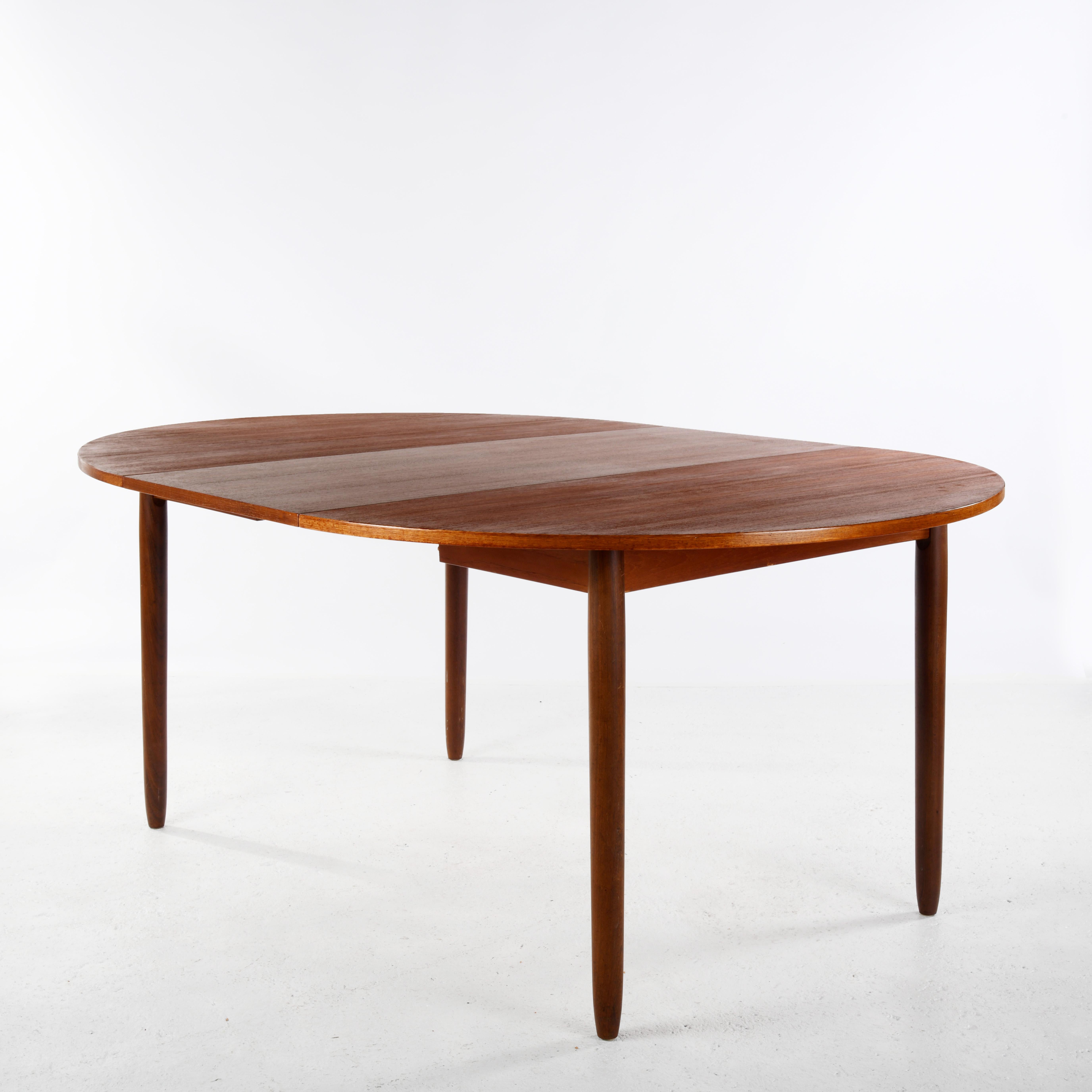 Scandinavian dining table from the 1960s, in teak veneer. The round top can be extended into an oval shape. As always, the extension leaf is a different colour because it has not been exposed to as much sunlight as the rest of the top. The top has