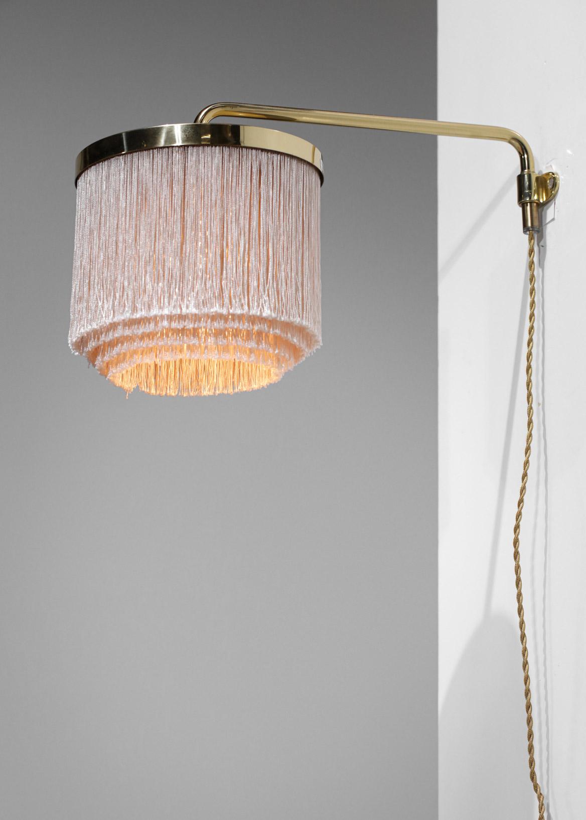 Wall lamp from the 60's by the Swedish designer Hans Agne Jakobsson. Solid brass structure and off-white silk fringed lampshade (pink reflections). Very nice vintage condition, led bulb recommended.