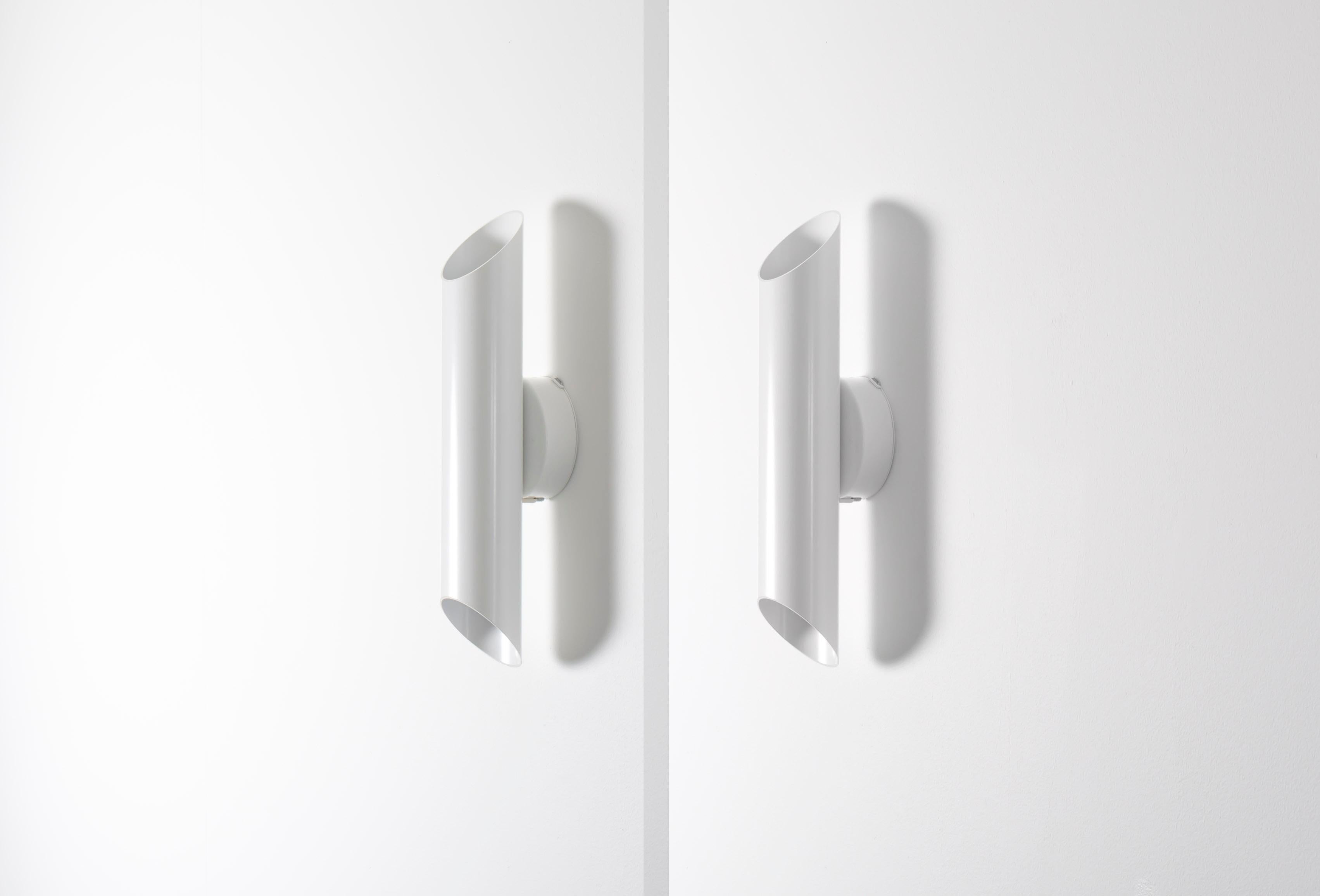 Maravillosa pareja de apliques de pared sobre una minimalista estructura de metal lacado. Modelo 