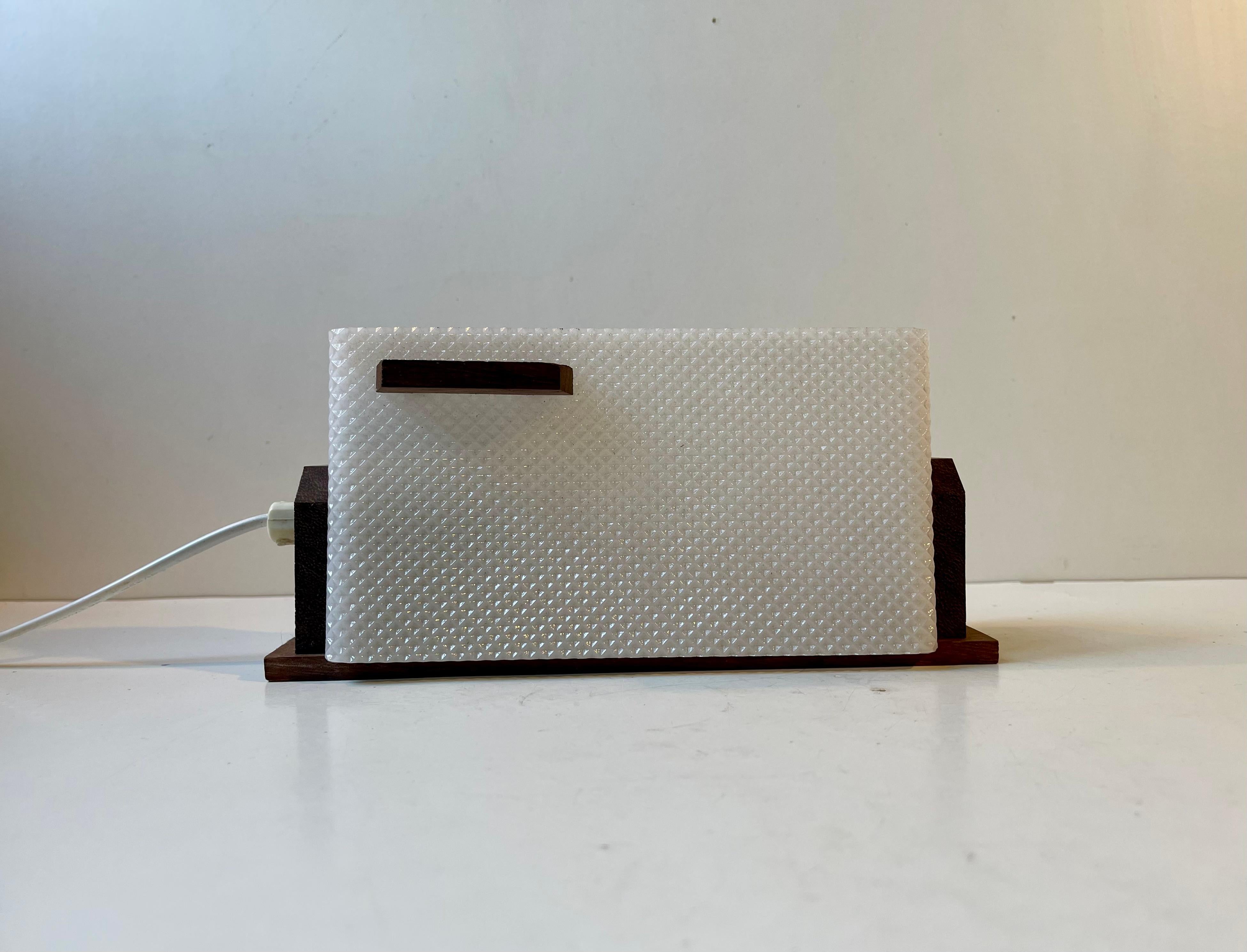 Une applique scandinave très discrète mais élégante en perspex texturé blanc courbé et en teck. La lumière s'ajuste de haut en bas et dans les deux sens et convient parfaitement comme lampe de chevet. Conçu par Lorentzons Epa et fabriqué par Lival