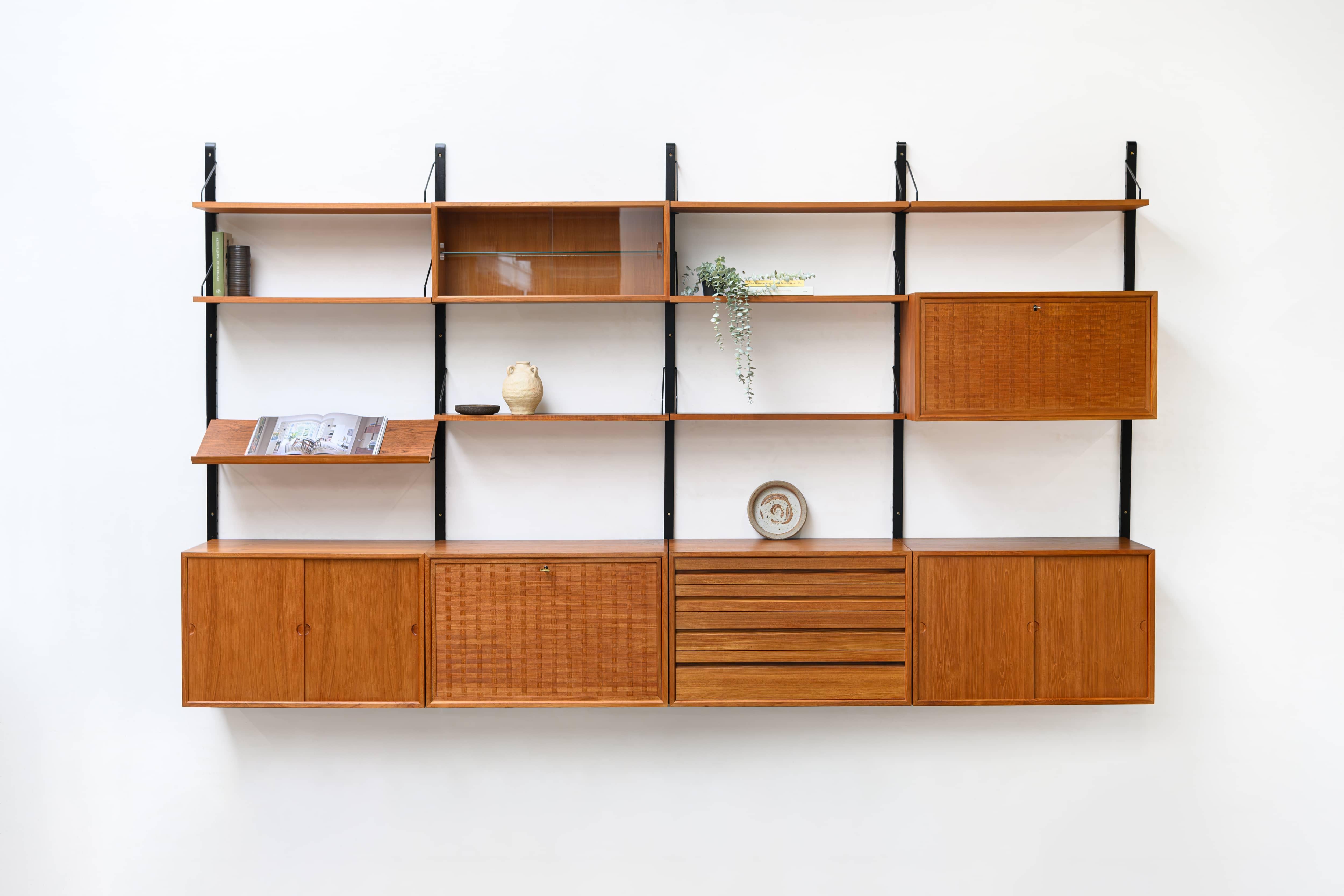 Danish modular wall unit by Poul Cadovius for Royal System. This teak setup has five storage cabinets, one display cabinet, one reading shelf and seven bookshelves. Always adaptable and further expandable.