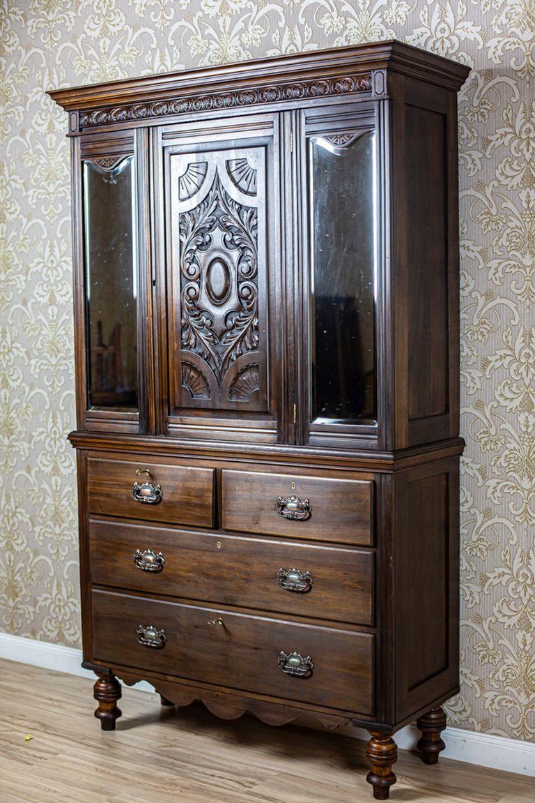 Scandinavian Walnut Buffet From the Early 20th Century in Dark Brown

A Scandinavian buffet made from solid walnut wood, dated before 1939. The piece comprises a base in the form of a chest of drawers with turned legs and a three-door upper section.