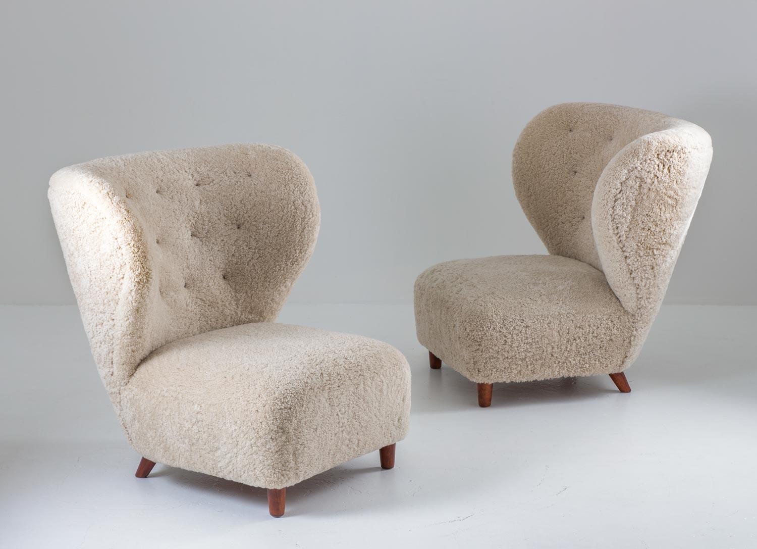 Pair of oversized sheepskin chairs by Danish cabinet maker, circa 1930.
These amazing chairs looks beautiful from any angle. They have been upholstered in off-white sheepskin with cognac leather buttons.

Condition: Excellent, fully restored and