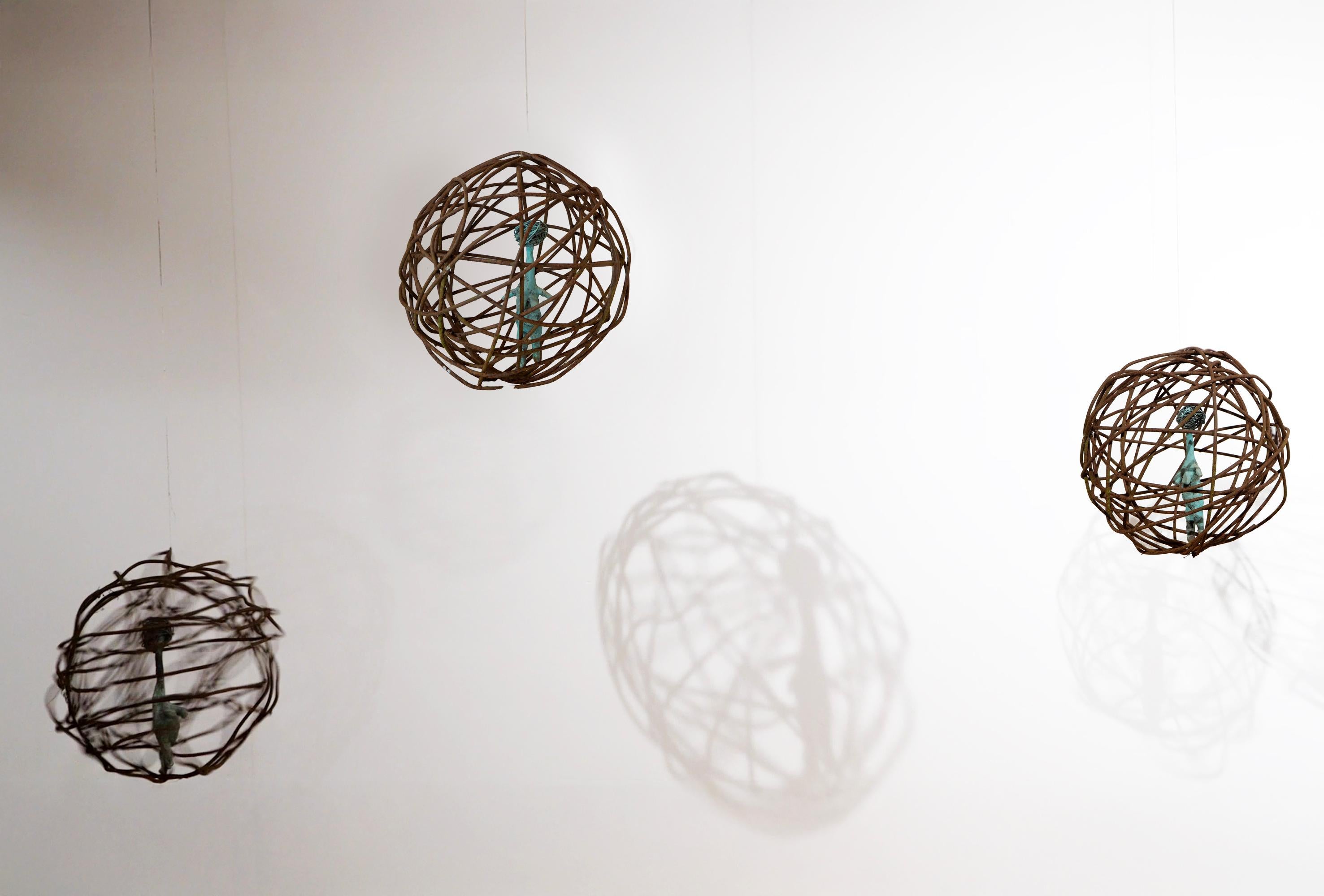 Donna in gabbia 2, figura contemporanea in bronzo verdastro sospesa in un orbita di ferro arrugginito in vendita 9