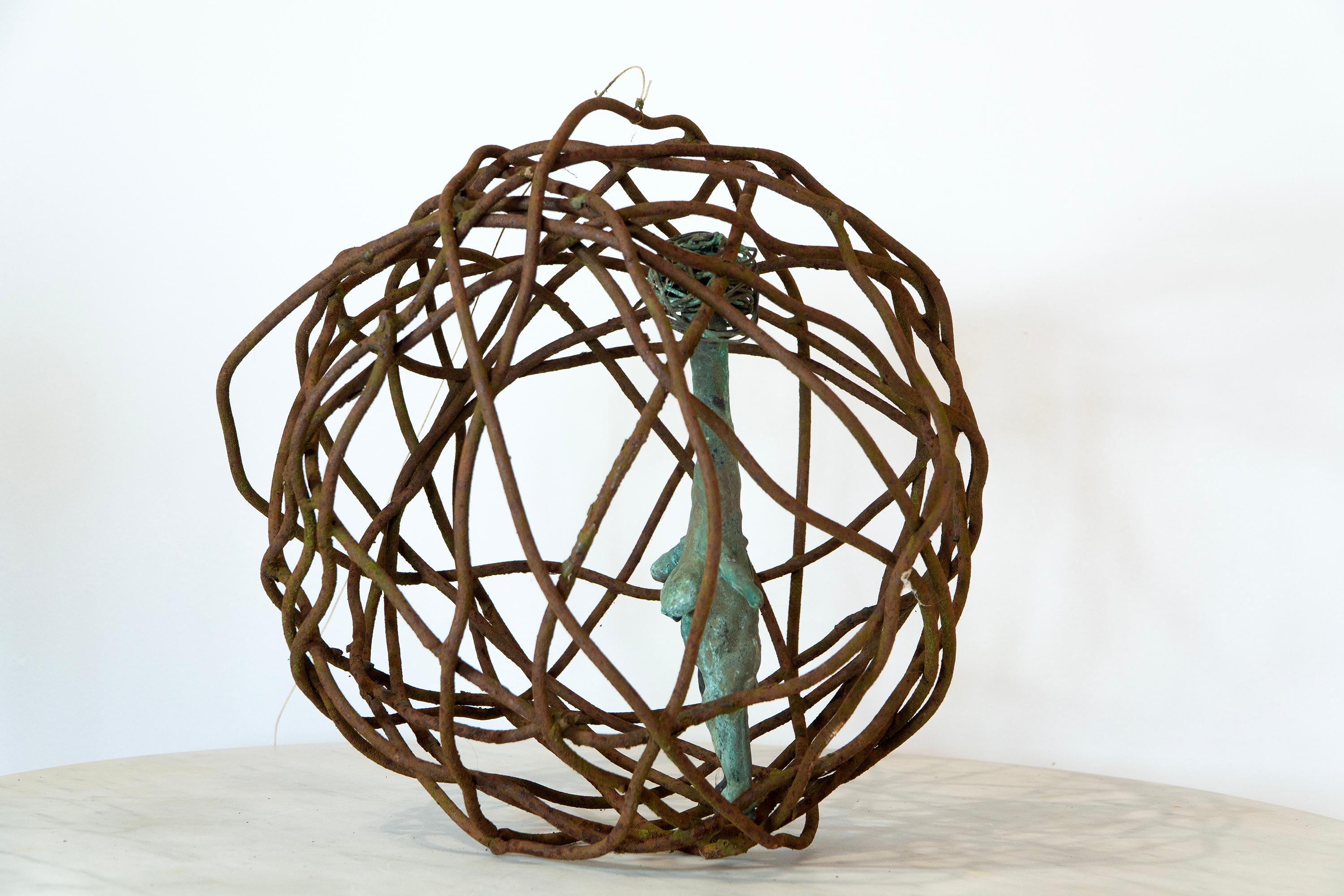 Le torse en bronze patiné suspendu dans un globe en fer rouillé évoque l'iconographie ancienne de Vénus et les thèmes contemporains de la contrainte et de la résilience. Caged Woman 3 (Ø 32 cm) d'Aldonza est coulée selon la technique traditionnelle