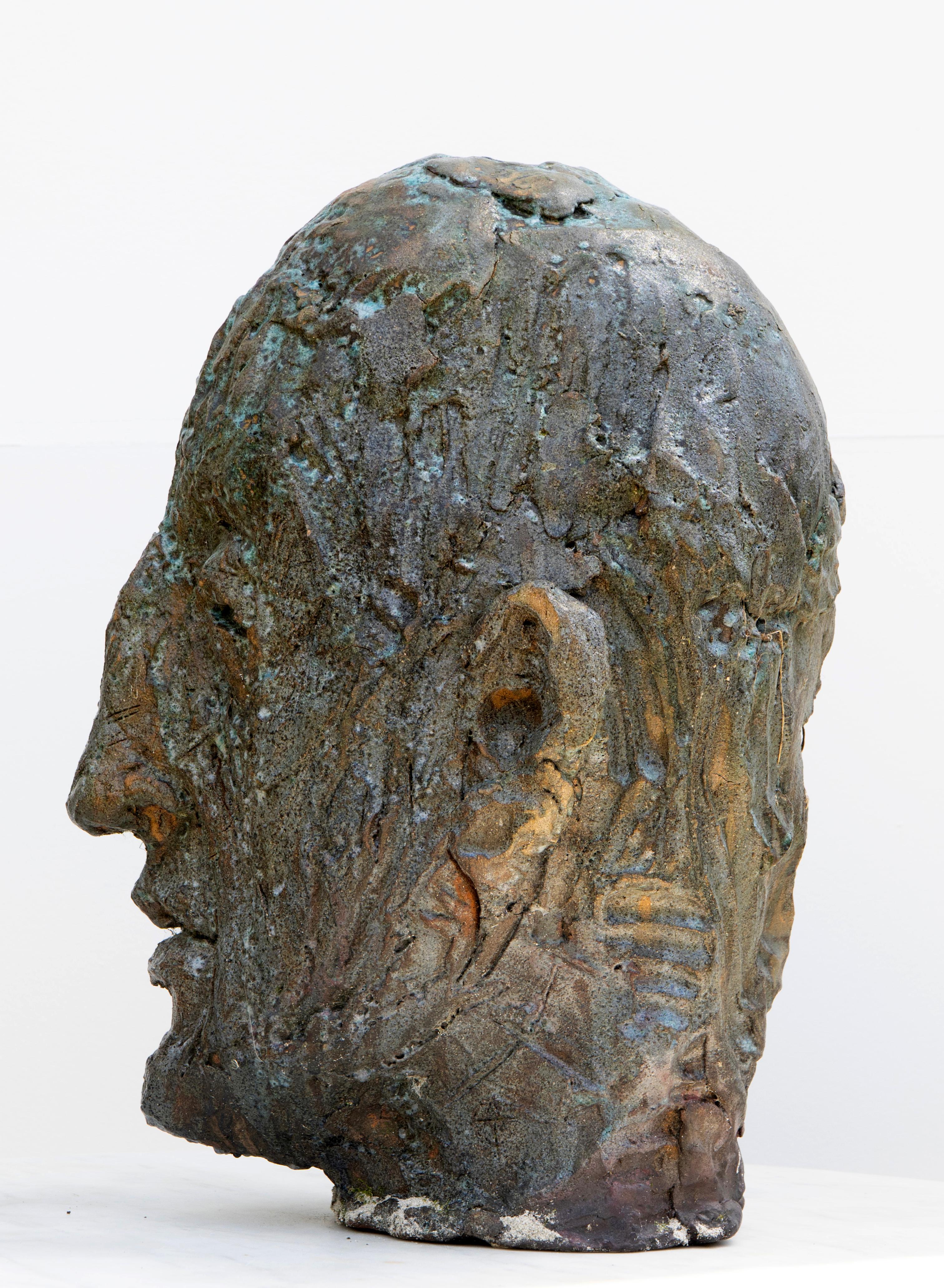 Sculpture de tête expressionniste en céramique réalisée en grès réfractaire avec une glaçure semi-transparente en cuivre. Cette tête en céramique appartient à la série Testas, un ensemble d'œuvres composées de têtes uniques en céramique qui