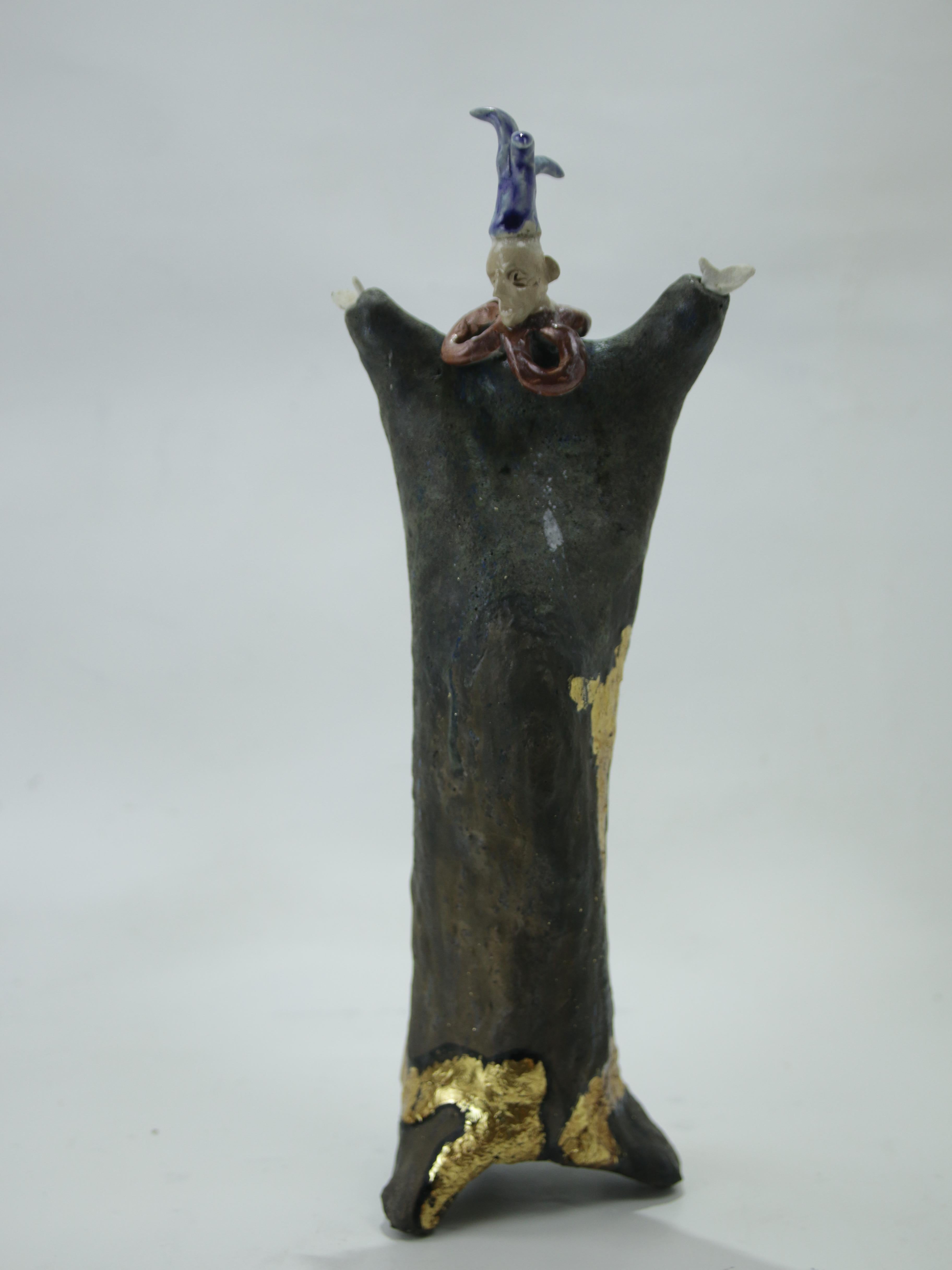 Contemporary hand built ceramic figurative sculpture featuring a tricorn hat character with dark glaze and gold accents.

Extravagant Tricorn Hat forms part of the Extravagantes series, a body of work in which the human figure is approached through