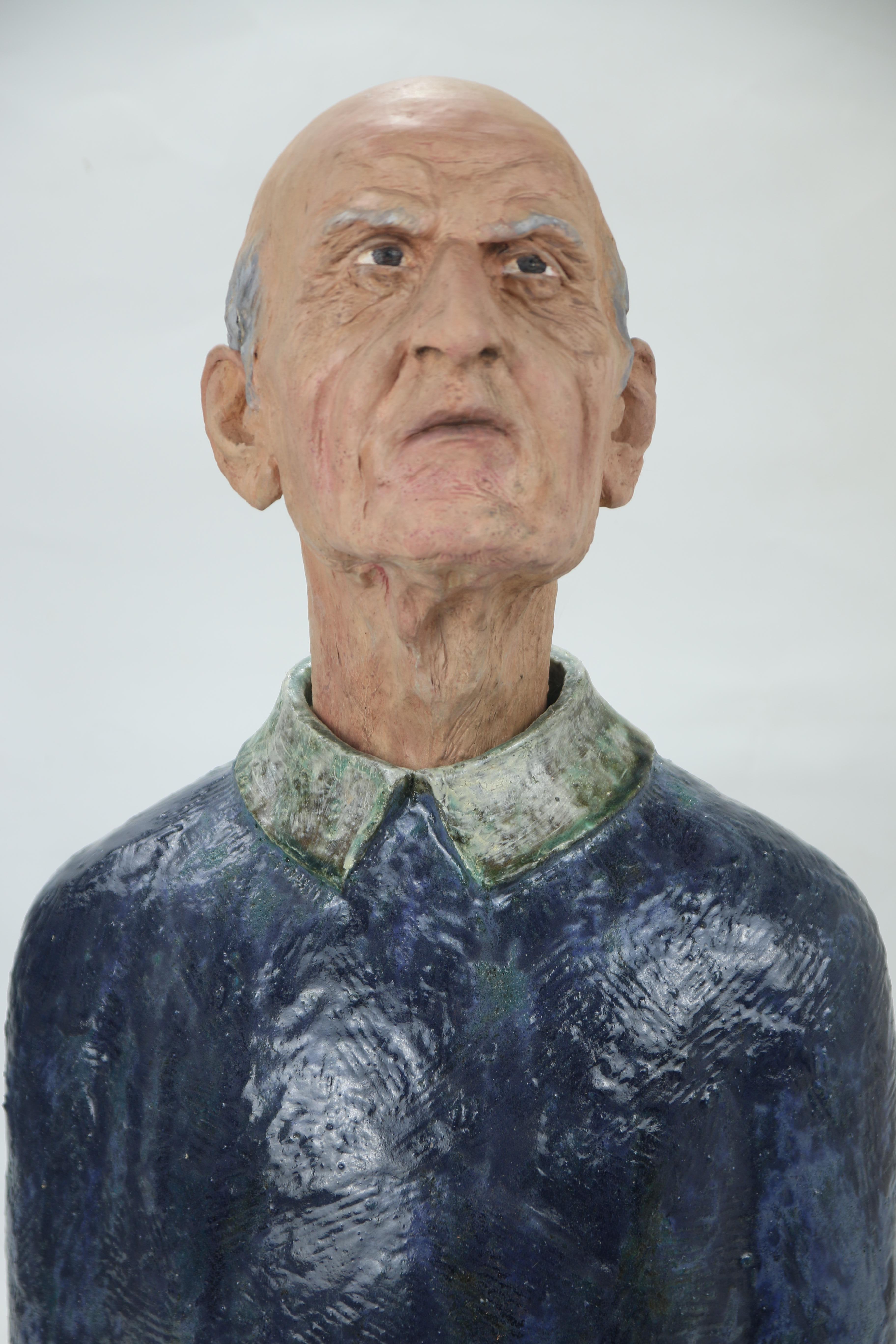 Expressive ceramic bust with high-fire glazes, oil-painted head and forged iron glasses exploring identity, learning and the aging body.

This expressive ceramic bust belongs to Os Aprendices, a series in which elderly heads are placed atop bodies