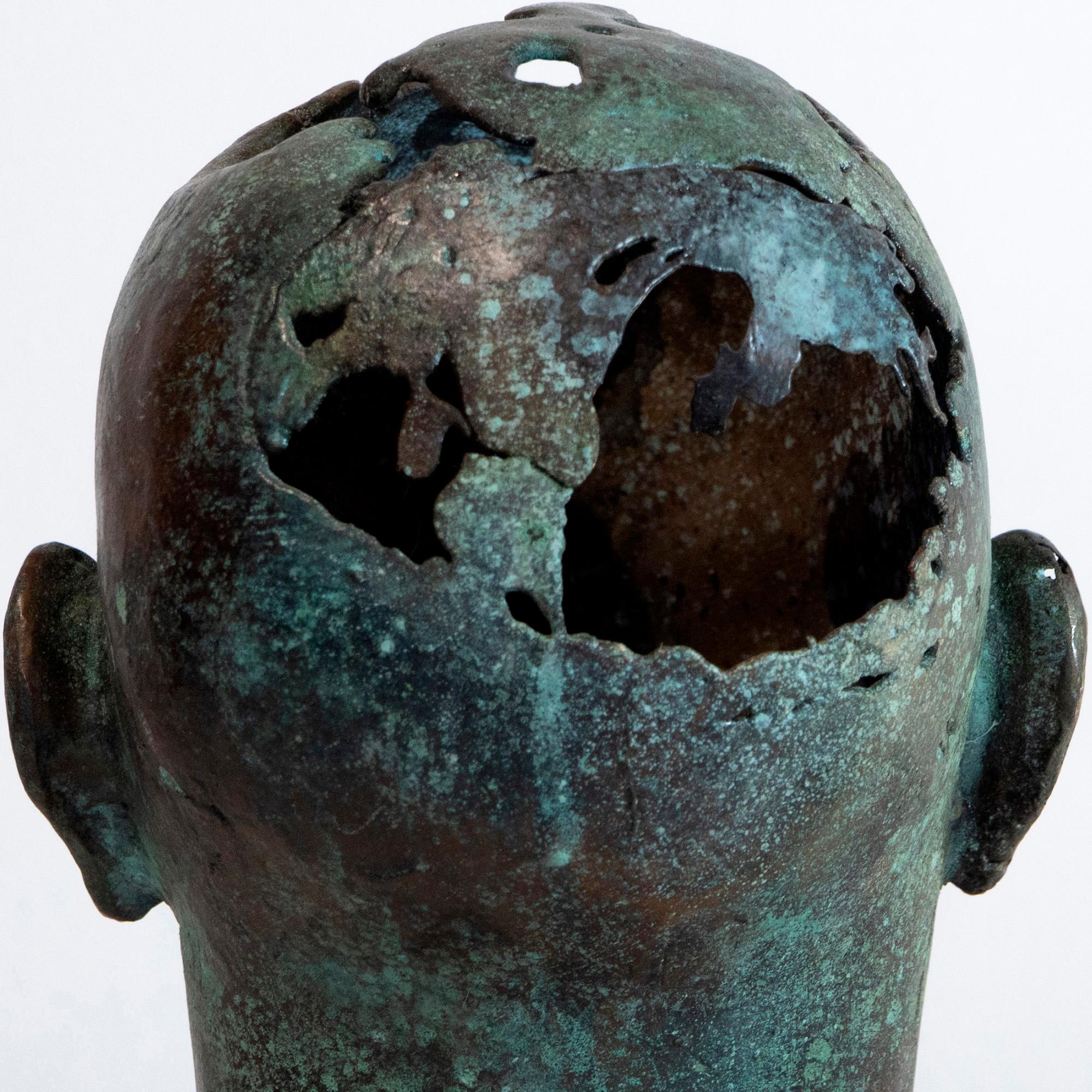 La scultura iperrealistica di una testa femminile in bronzo con cranio incavato evoca mistero e patina organica. Soño (24 × 17 × 22 cm) di Aldonza è stato fuso dall'artista con la tradizionale tecnica della cera persa, ottenendo un viso liscio e