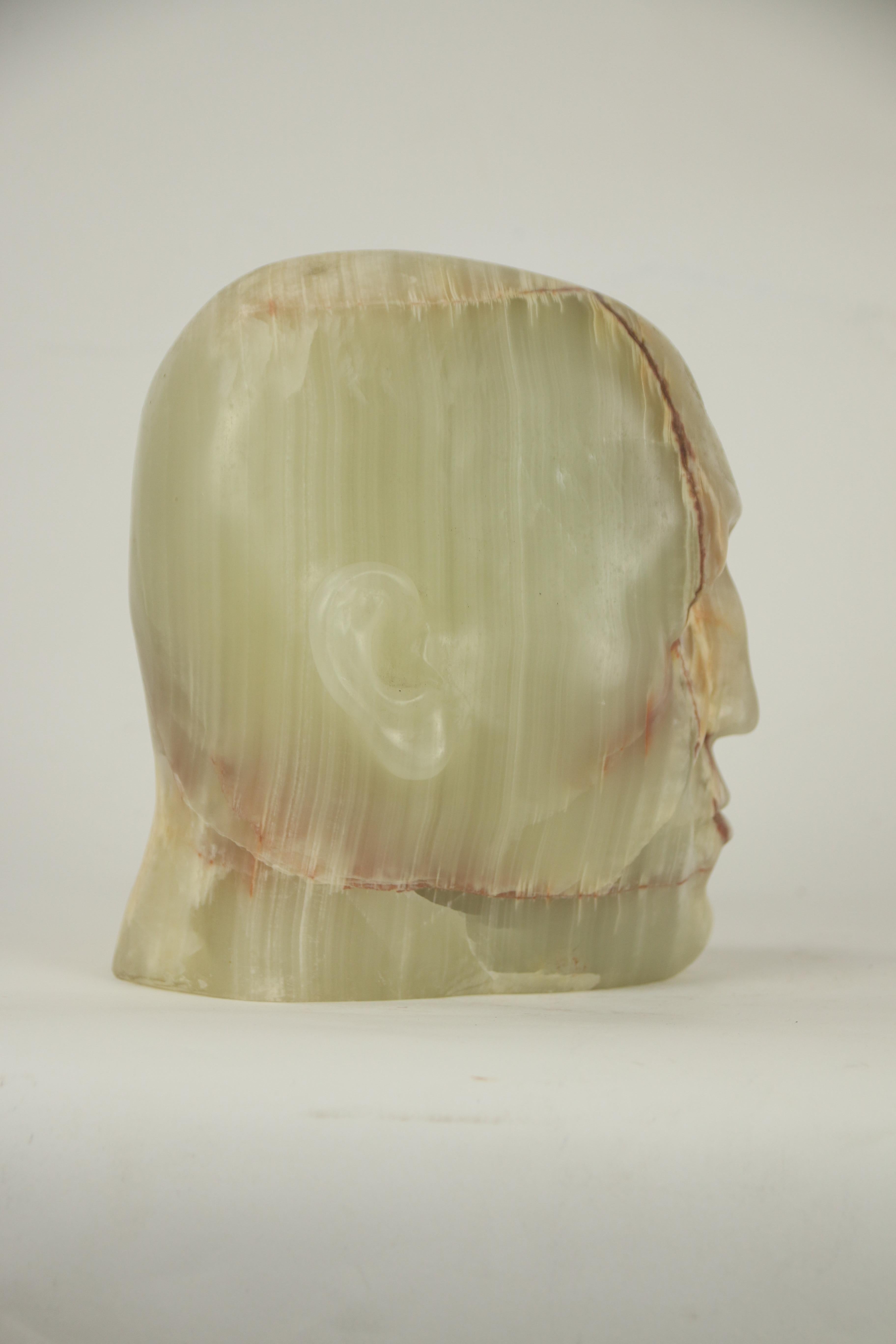 Scultura di testa in alabastro traslucido con venature naturali espressive, scolpita in intaglio diretto per un gioco unico di luce, pietra e forma umana.

Questa scultura unica di testa di alabastro è stata scolpita per intaglio diretto,