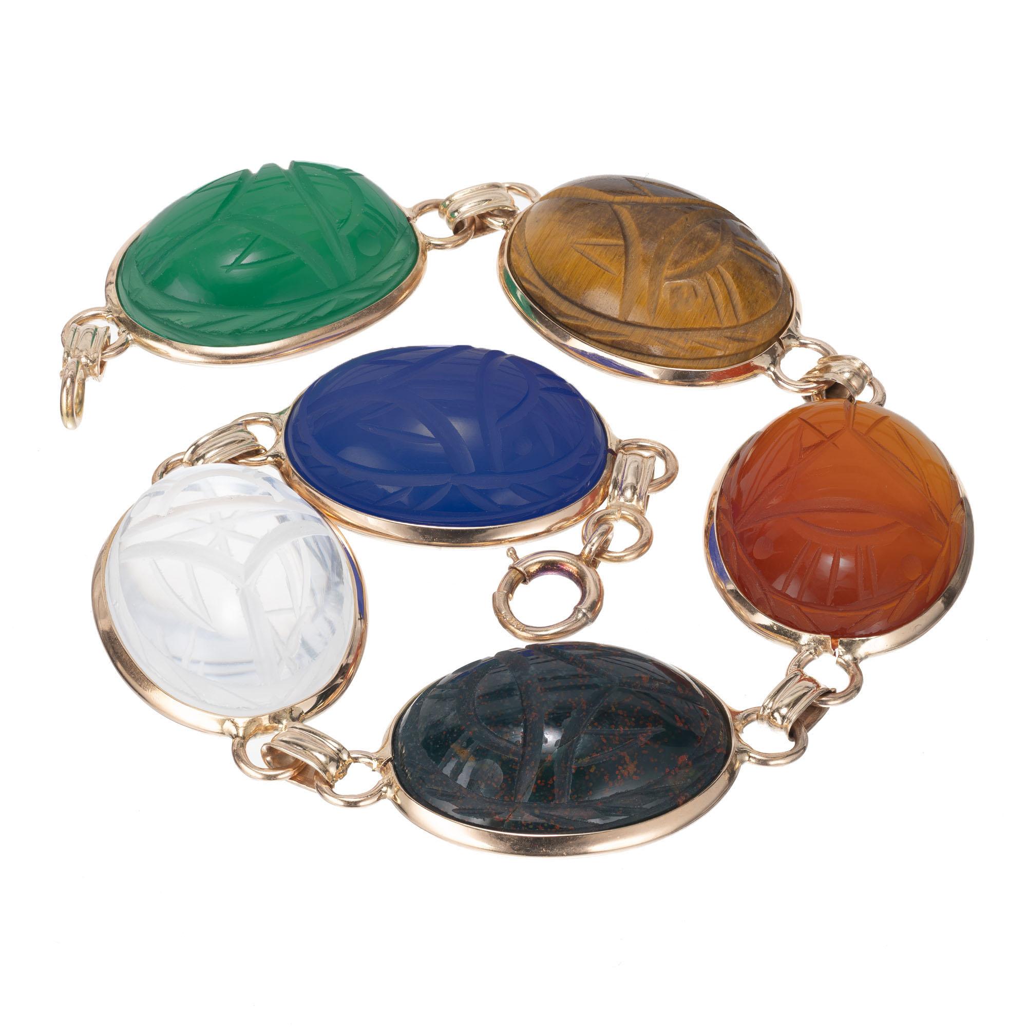 Authentic 1940 14k yellow gold large Scarab bracelet. Multi-color Quartz stones carved front and back in gold bezels. The Scarab is the Egyptian symbol for eternal life.

1 oval Chrysophase 19.47 x 14.71 x 6.71mm
1 oval Tiger eye
1 oval