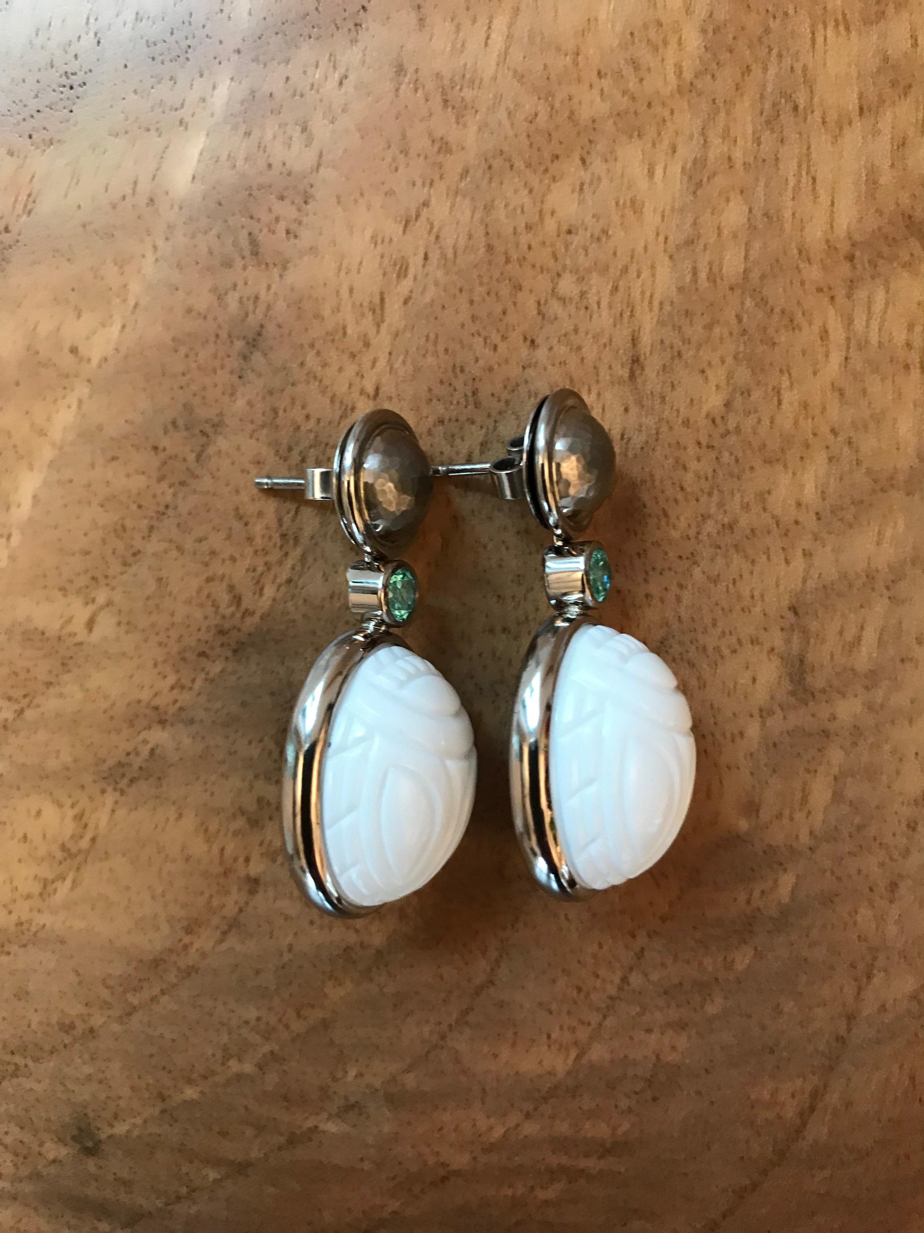 A pair of white gold dangle earrings with two cacholong scarabs 31.66 ct and two african paraiba tourmalines 0.53 ct. Just beautiful.
Designed by Colleen B. Rosenblat