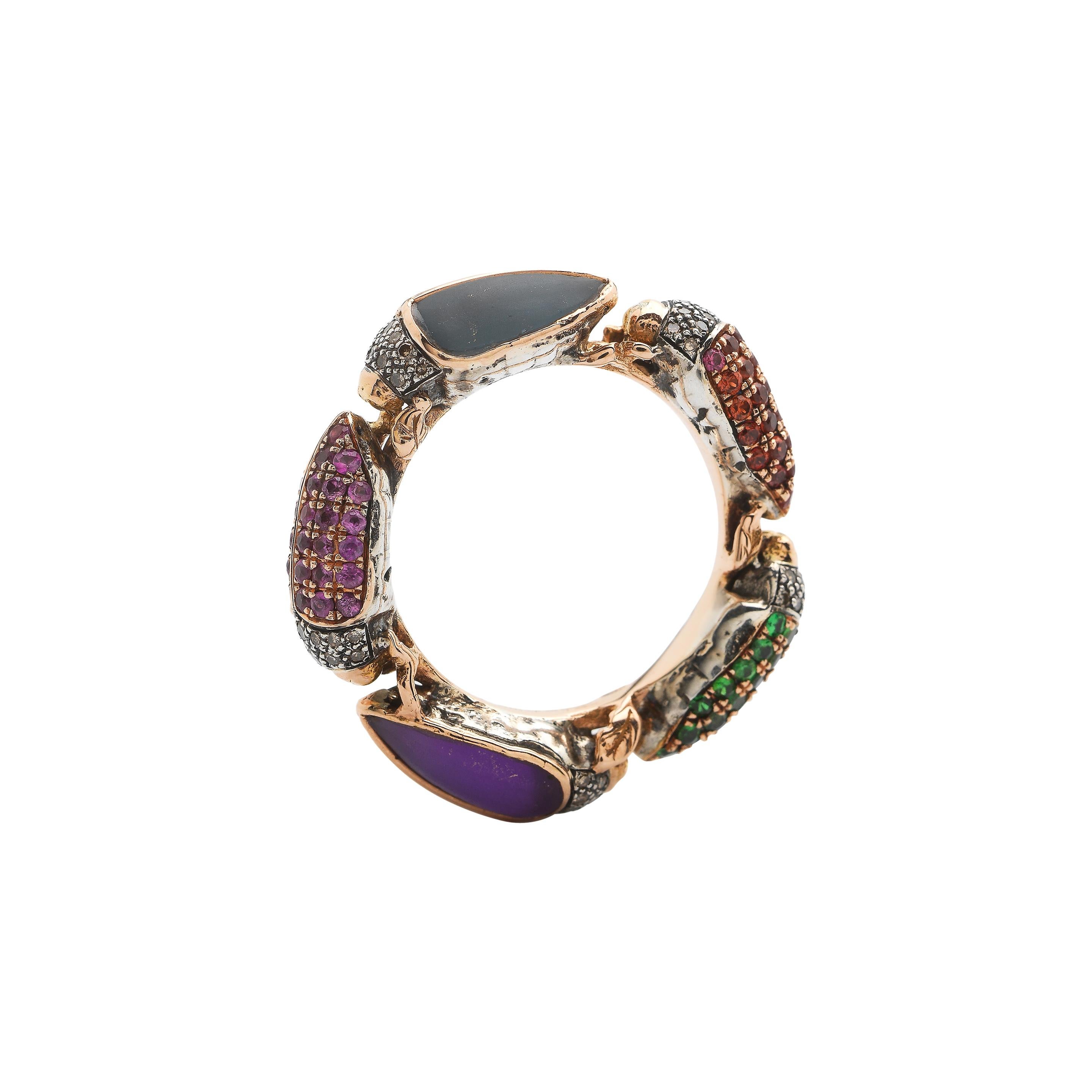 Five beautiful scarab beetles joined together make up the Scarab Eternity Ring, designed in 18k rose gold and sterling silver. The beetles in this ring are set with brown diamonds, amethyst, multi-coloured sapphires, blue topaz and tsavorites, but