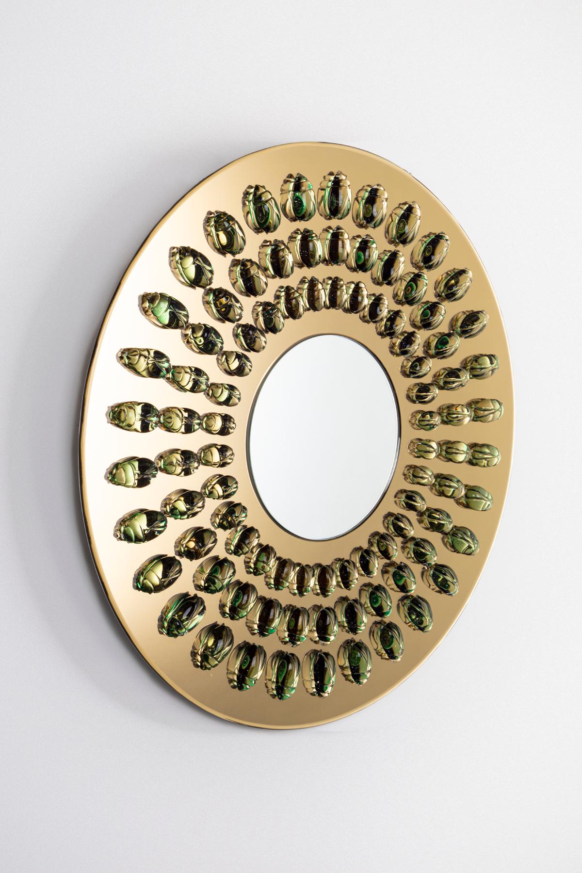The geometrical arrangement of the glass scarabs on
this rounded mirror create order out of the insects’
sinuous exoskeletons. The increasing scale moving
outward from the center allude to the delicate stage
of metamorphosis.



Duetto is a