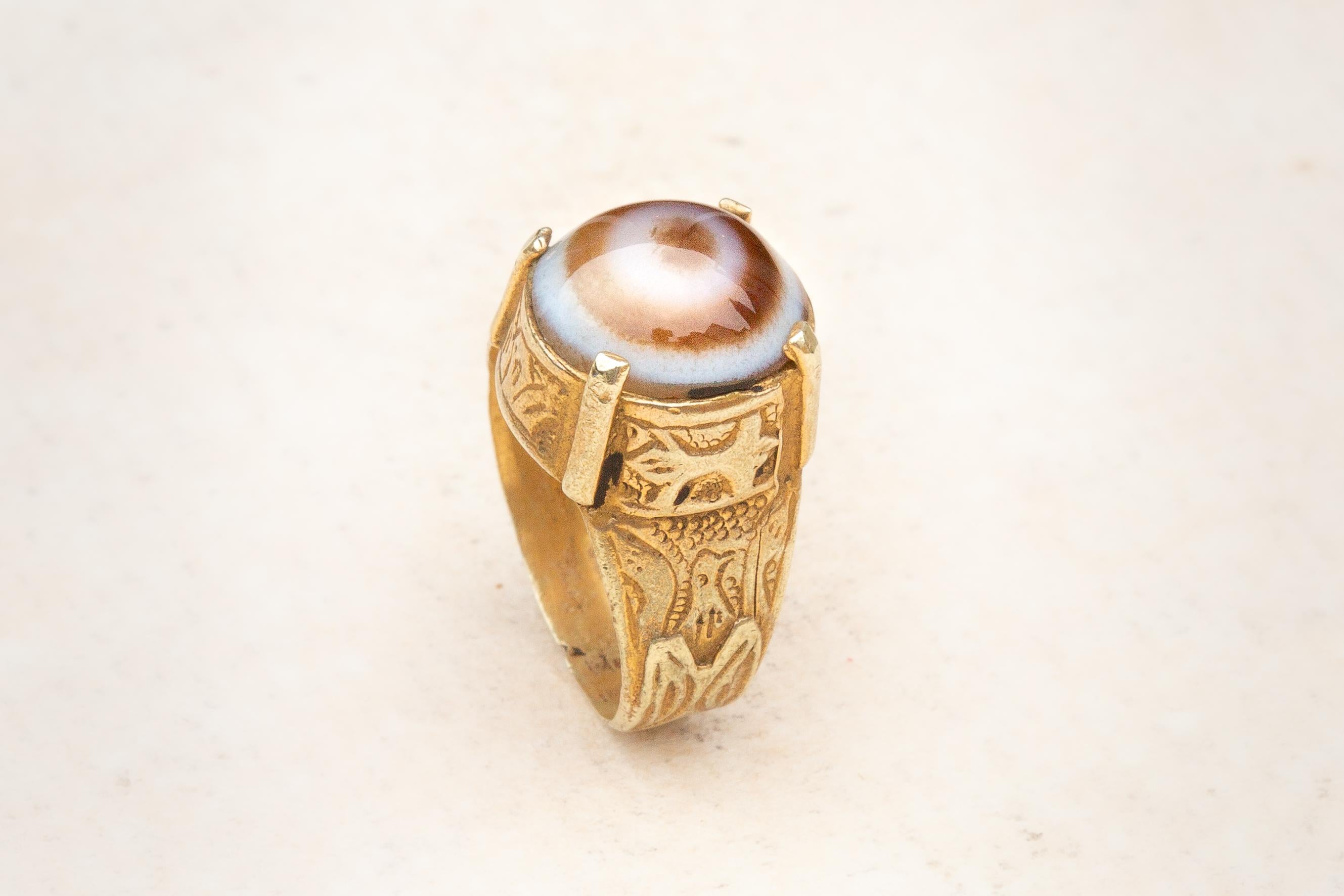 A superb Islamic gold and agate ring dating from the 13th to 14th century. The brown ‘sheep’s eye’ agate cabochon sits within a truncated conical bezel with a four-pronged setting soldered to the outside, typical of Seljuk dynasty rings. In the