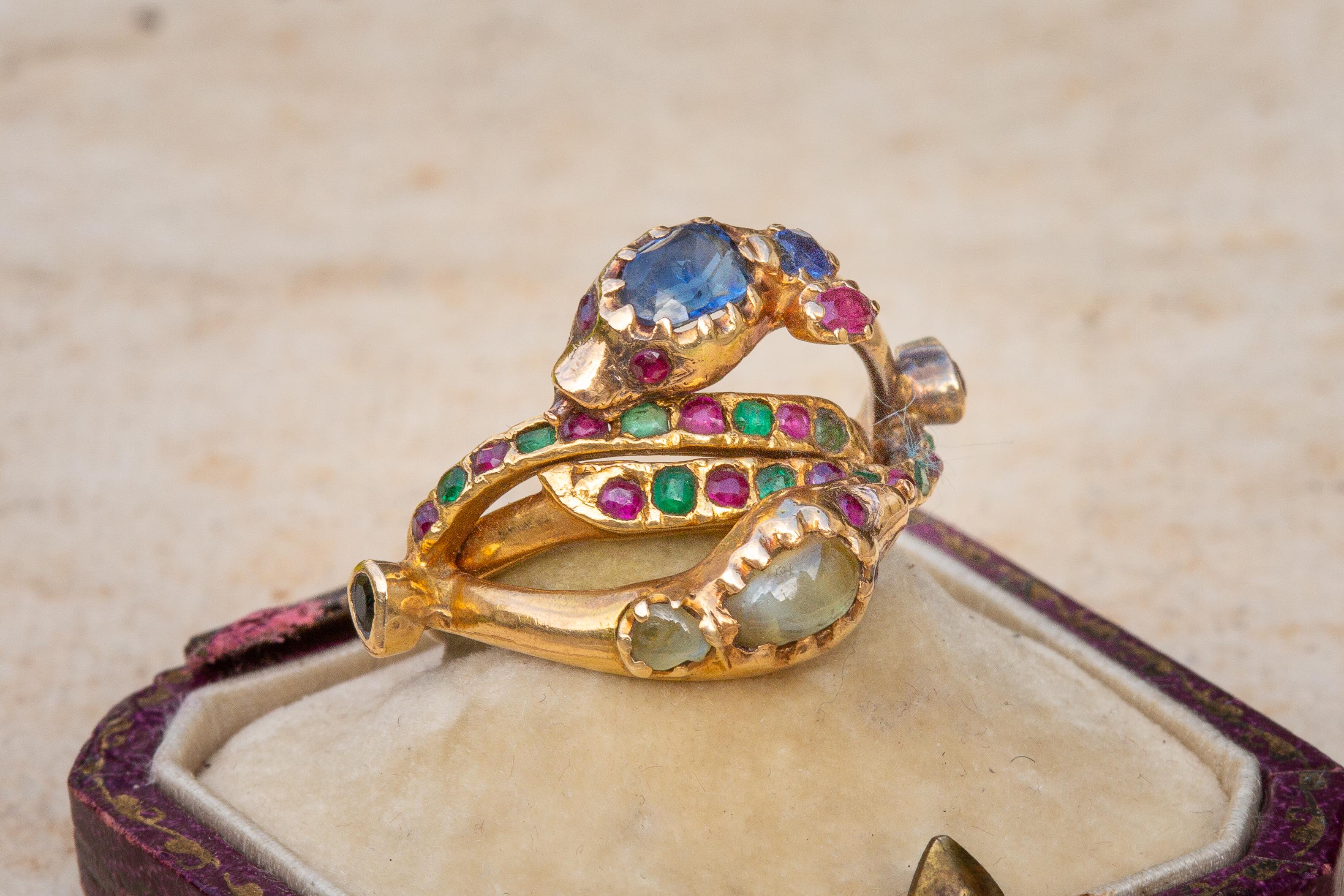 Crafted from two individual gold bands, these coiled serpents lock together to form a beautiful intertwined double snake ring. 

Intricate and unusual in design, this ring crafted was a challenging commission. The eyes are set with rubies, the