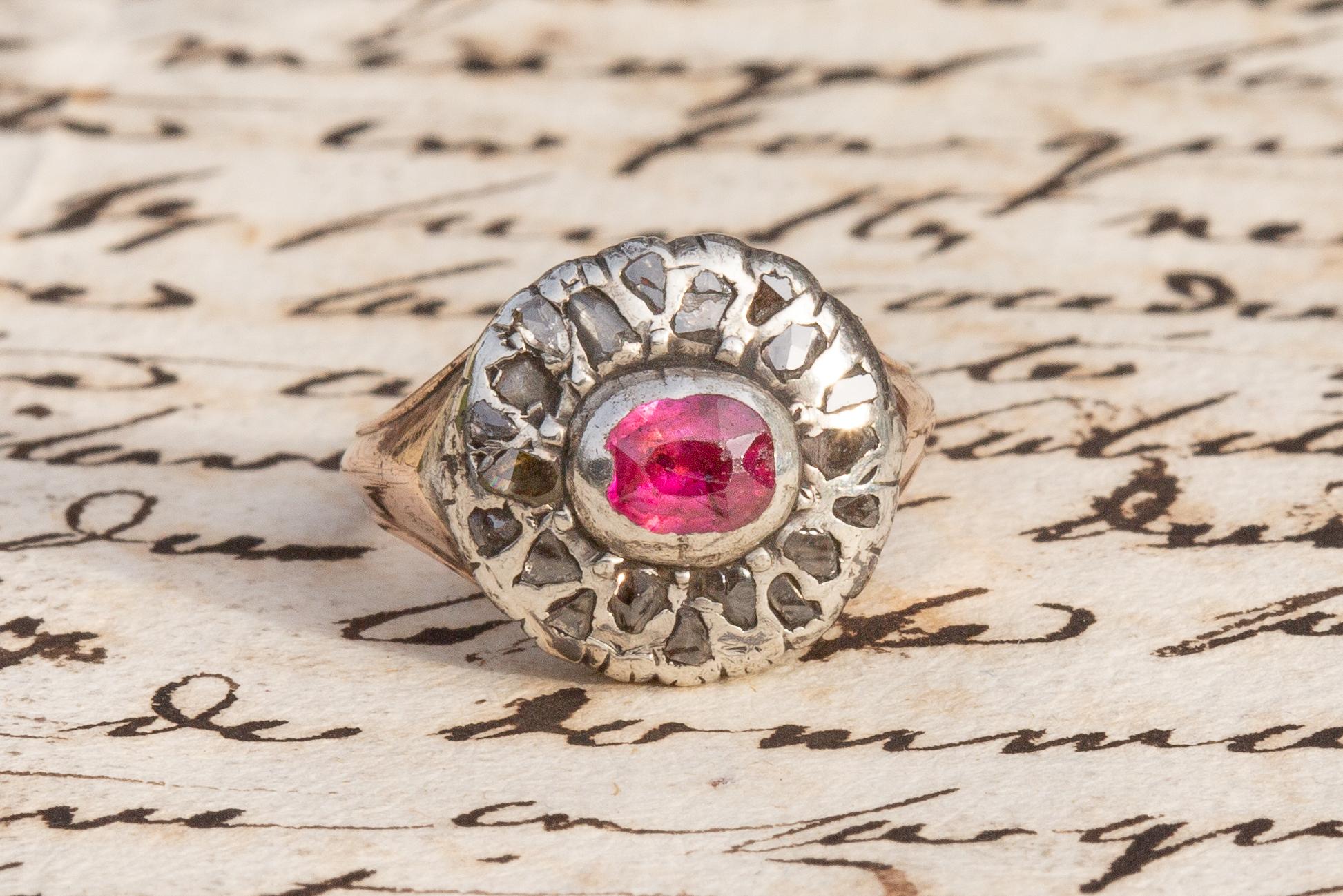 Dieser ungewöhnliche, antike, florale Rubin- und Diamantring aus der georgianischen Ära um 1800 wurde wahrscheinlich in Italien hergestellt. In der Mitte des Ringkopfes liegt ein mit einer Spannzange gefasster und mit Folie hinterlegter hellrosa