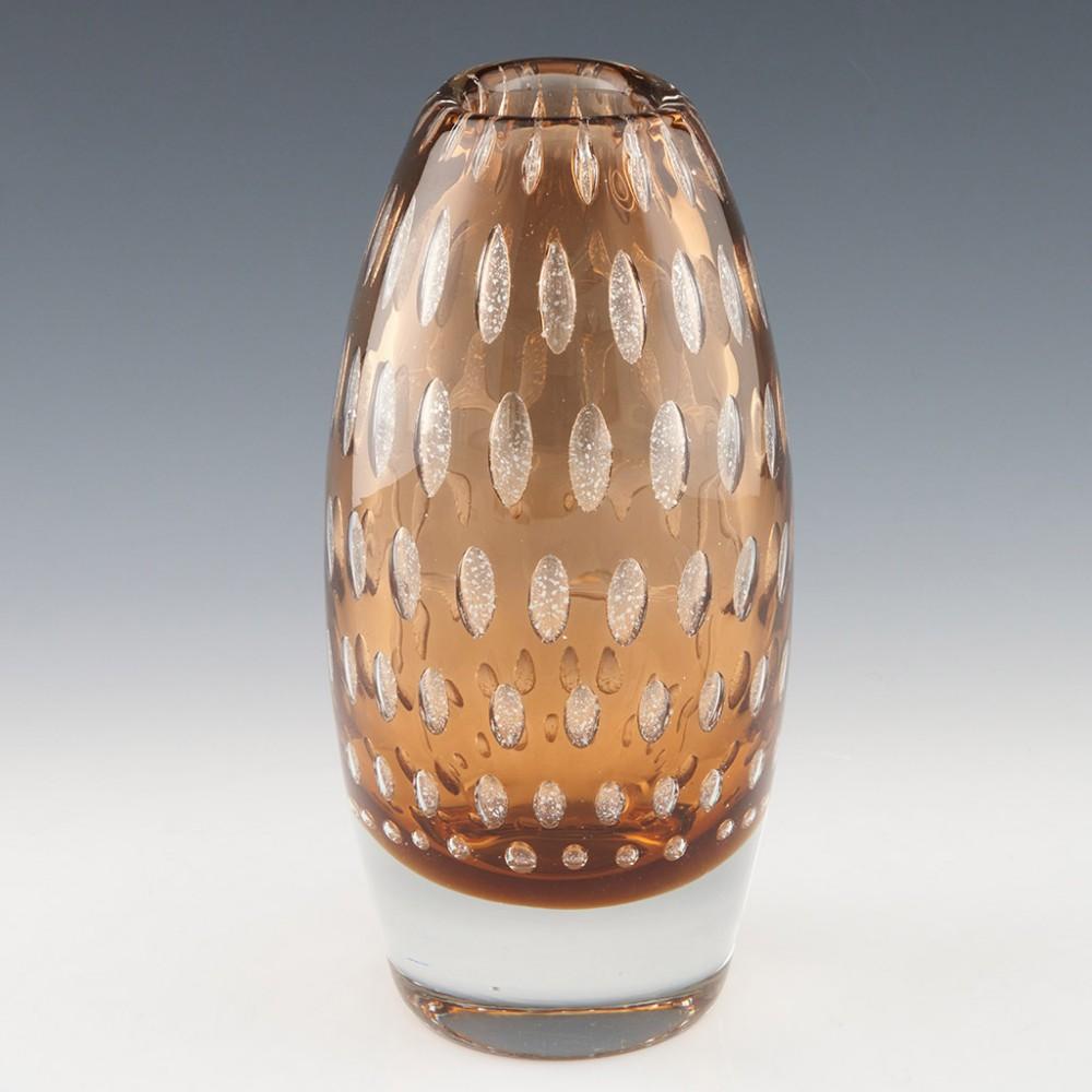 Heading : Harrach Amber Mica Frit Vase
Date : 1968
Origin : Milan Metelak fort Harrach, Czechoslovakia
Bowl Features : Amber glass case in clear with internal controlled air bibbles containing mica
Type : Lead
Size : Height 23.3cm maximum width