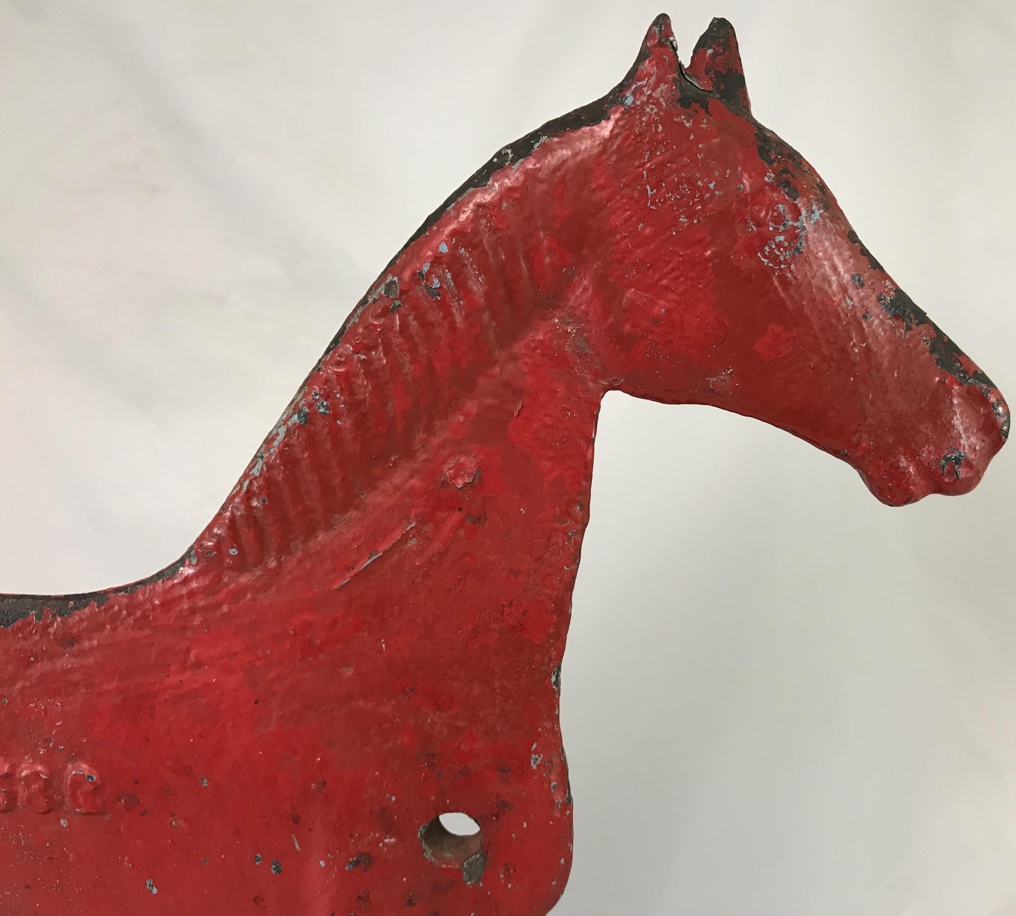 A fine scarce example of a red painted iron short tail horse form windmill weight, American, dating to the late 19th century, manufactured by Dempster Mill Manufacturing Company of Beatrice, Nebraska.This weight was used to counterbalance the vanes