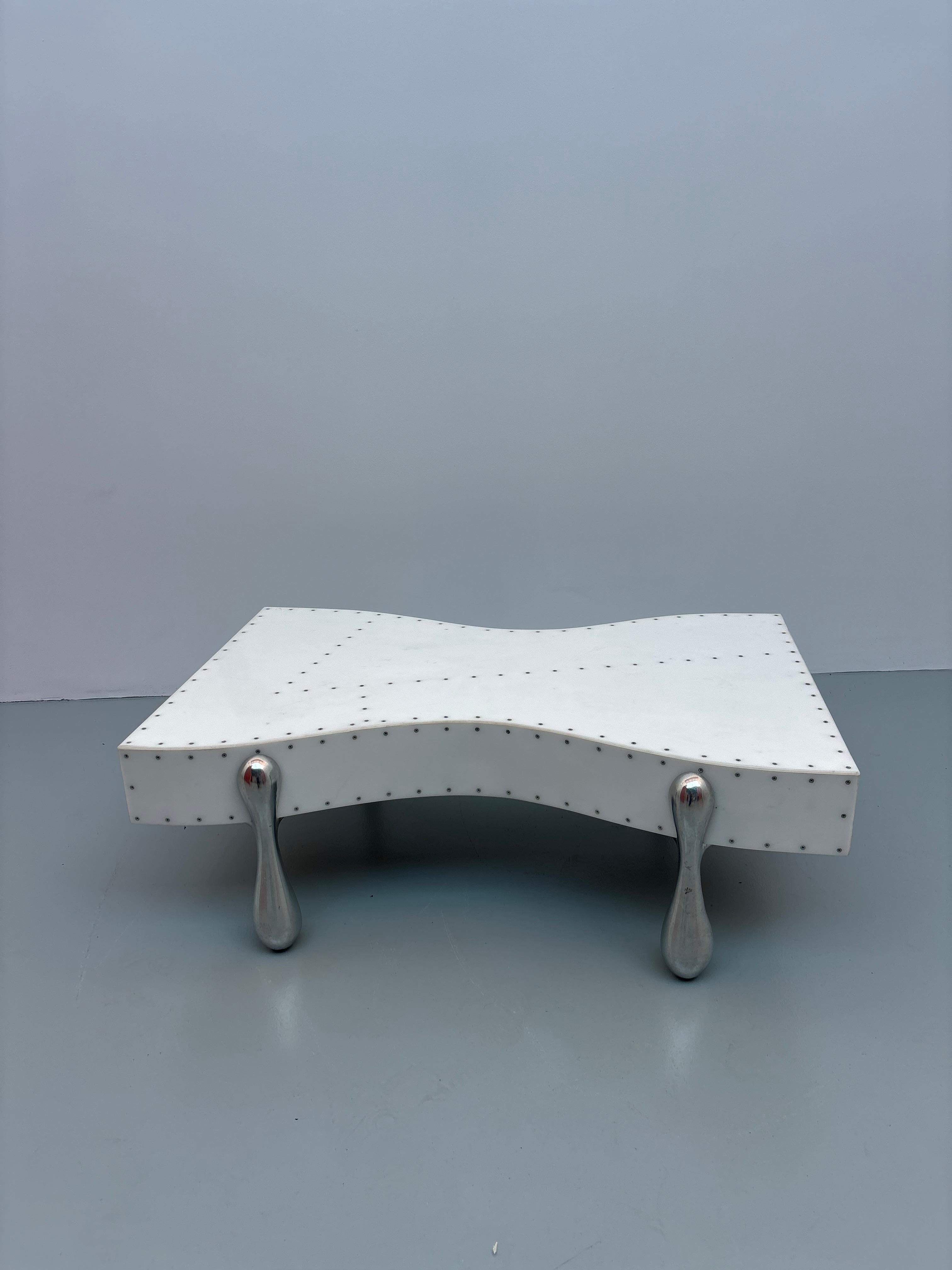 Pucci DE ROSSI (1947-2013) Table basse X, le plateau couvert d'un plexiglas blanc à vis apparentes, pieds en métal chromé.  Vers 1980

Reproduit dans la monographie. 