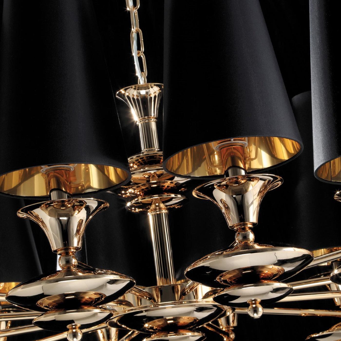 This captivating chandelier will stand out in both a modern and classic interior, thanks to its combination of elegant finishes. The 12 black shades are made of rigid fabric and feature a truncated cone shape, while the brass and metal structure