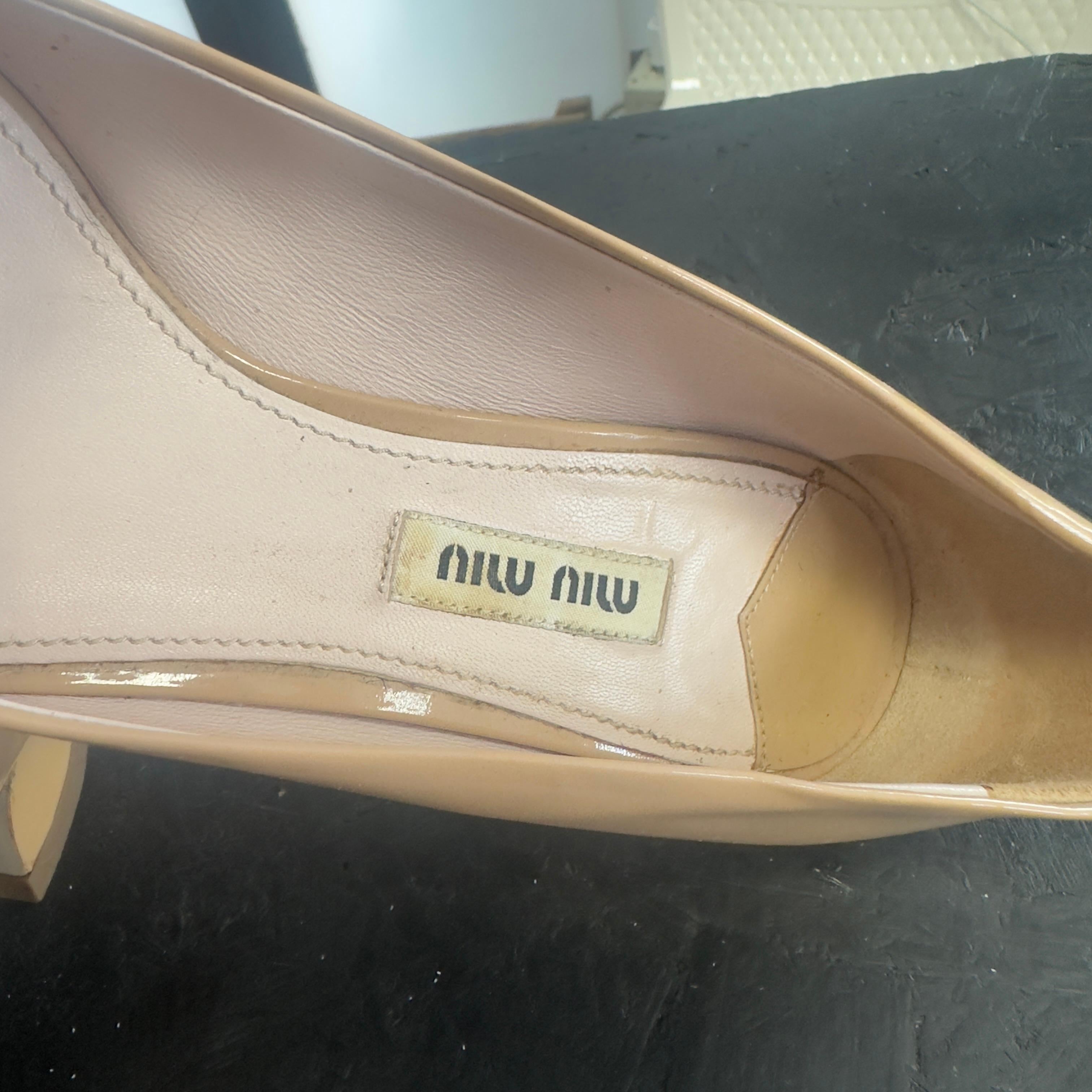 Decoltè Miu Miu spuntate in vernice color nude. Ad impreziosirle due file di strass applicati a strisce ed un grande fiocco davanti
Numero 36,5, buone condizioni, dotate di scatola