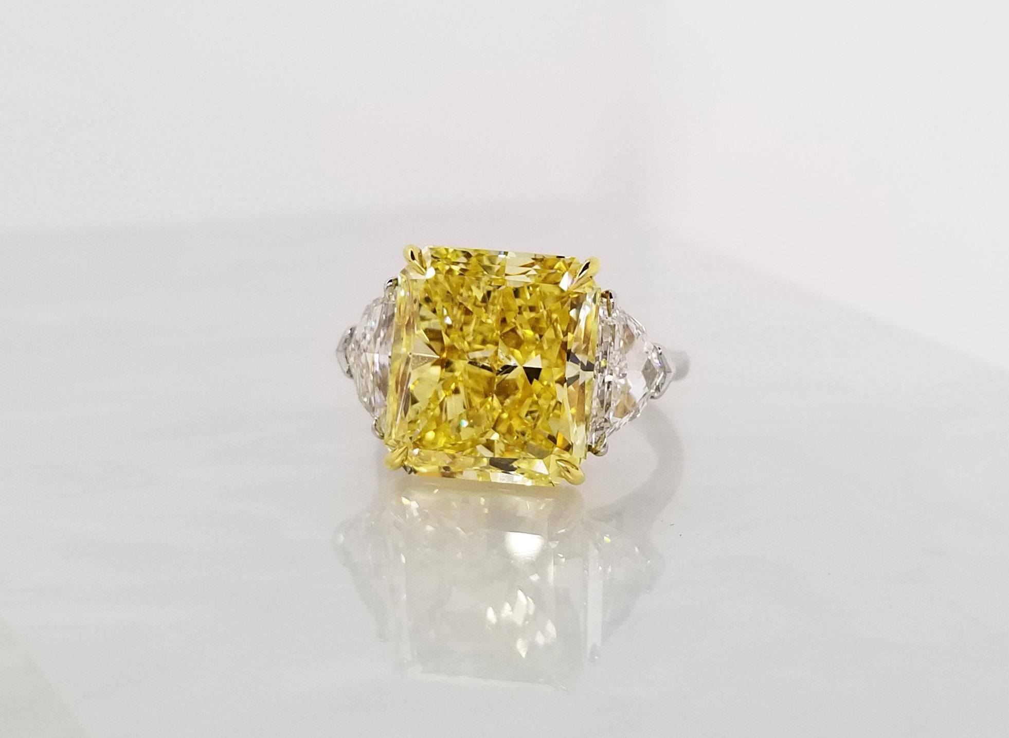 This Beautiful Classic Ring From Scarselli features a 10 carat Fancy Vivid Yellow Radiant Cut Diamond with GIA certificate 2165563315 (See certificate picture for detailed stone information). The center diamond is guarded by 2 half-moon white