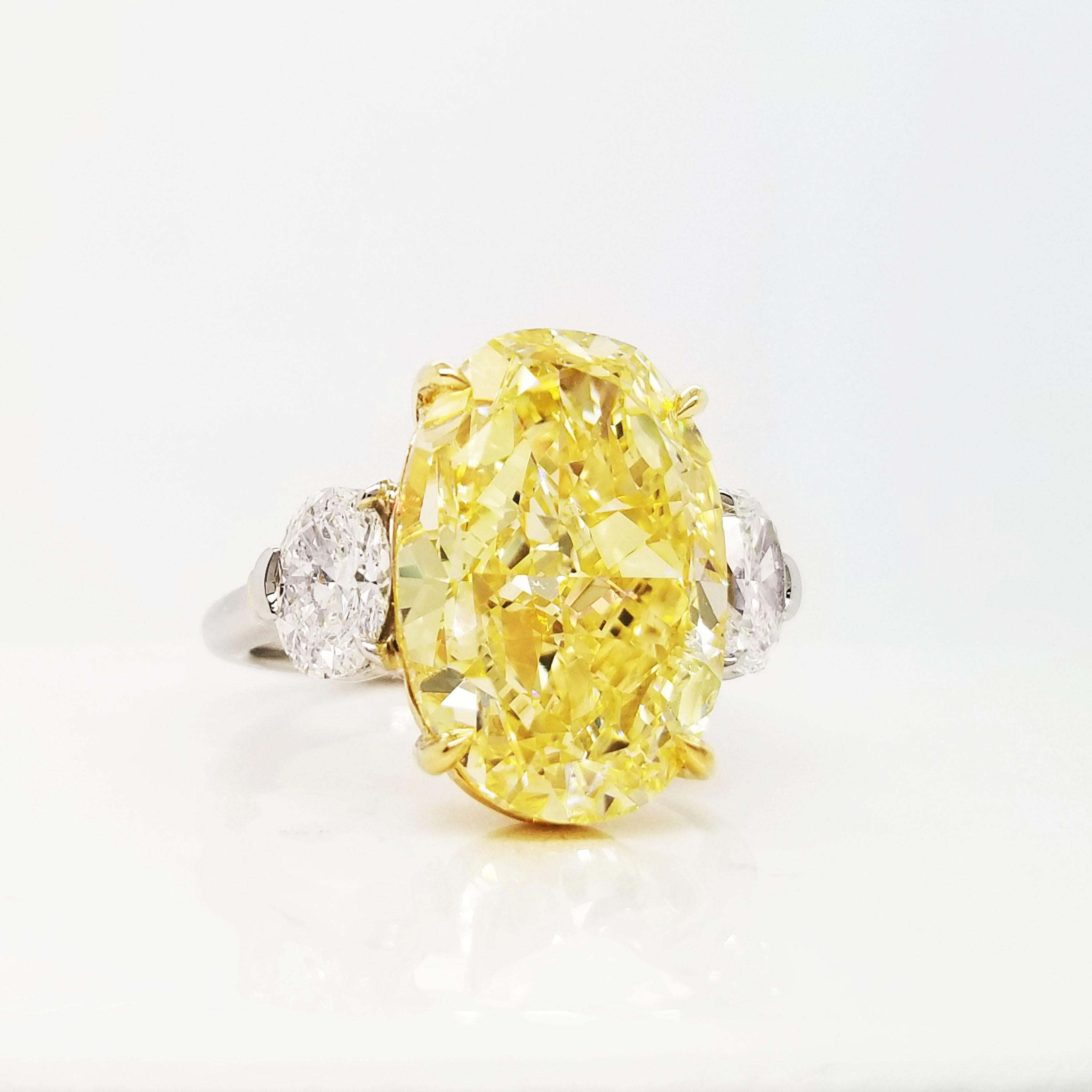 Ein ovaler 10-Karat-Diamant in intensivem Gelb, der an den Seiten von zwei weißen Ovalen von je 0,50 Karat in der Farbe F und der Reinheit VS1 flankiert wird. Die drei Steine sind professionell von GIA zertifiziert (siehe Zertifikat Bilder für