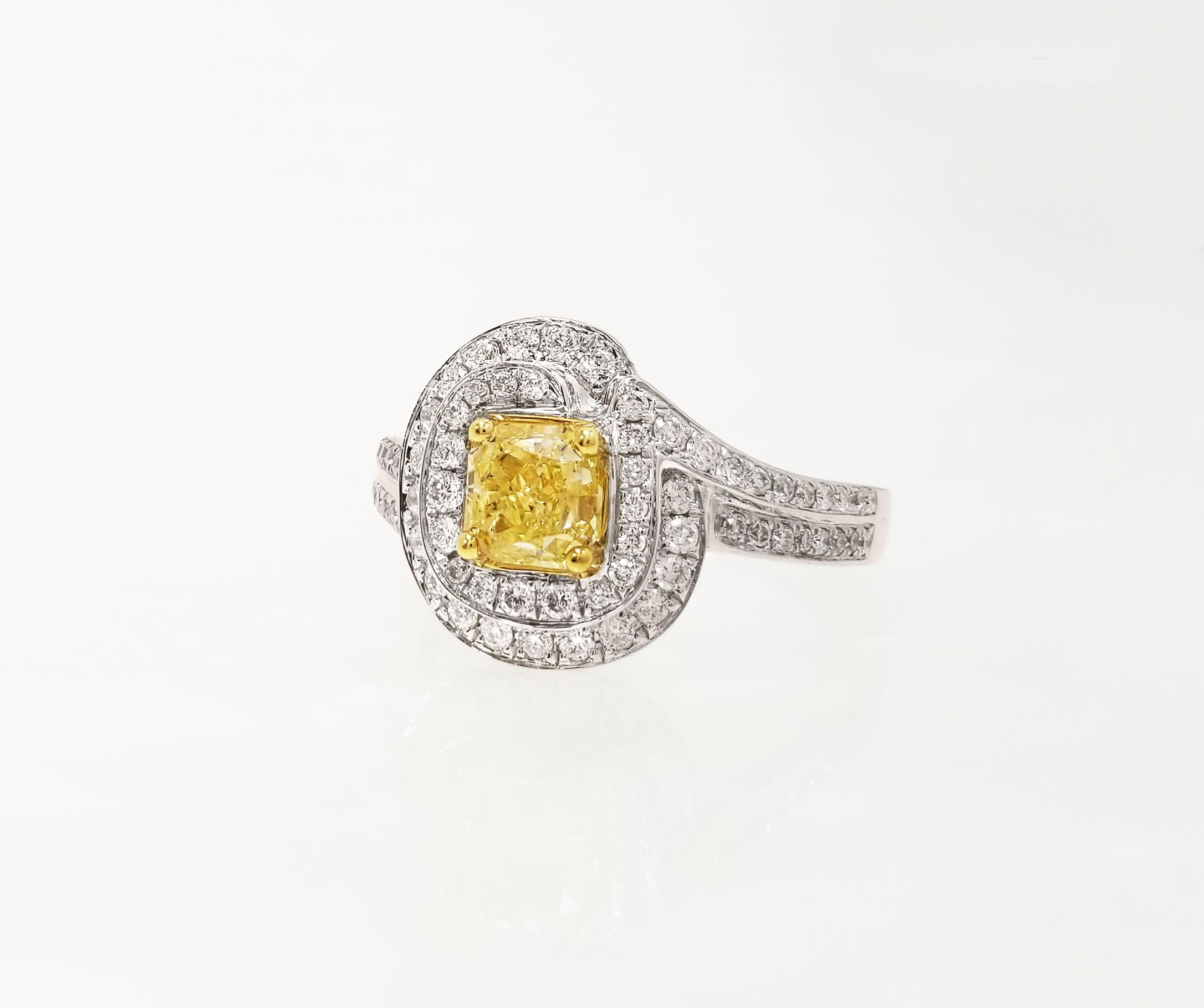 GIA-Certified Natural Fancy Yellow 1.05 Carat Radiant-cut VVS2 Diamond Engagement Ring on 18k White Gold Band. Featuring 2 rows of round-brilliant white diamonds in a spiral halo design – perfect as a statement or engagement ring. Ring is resizable