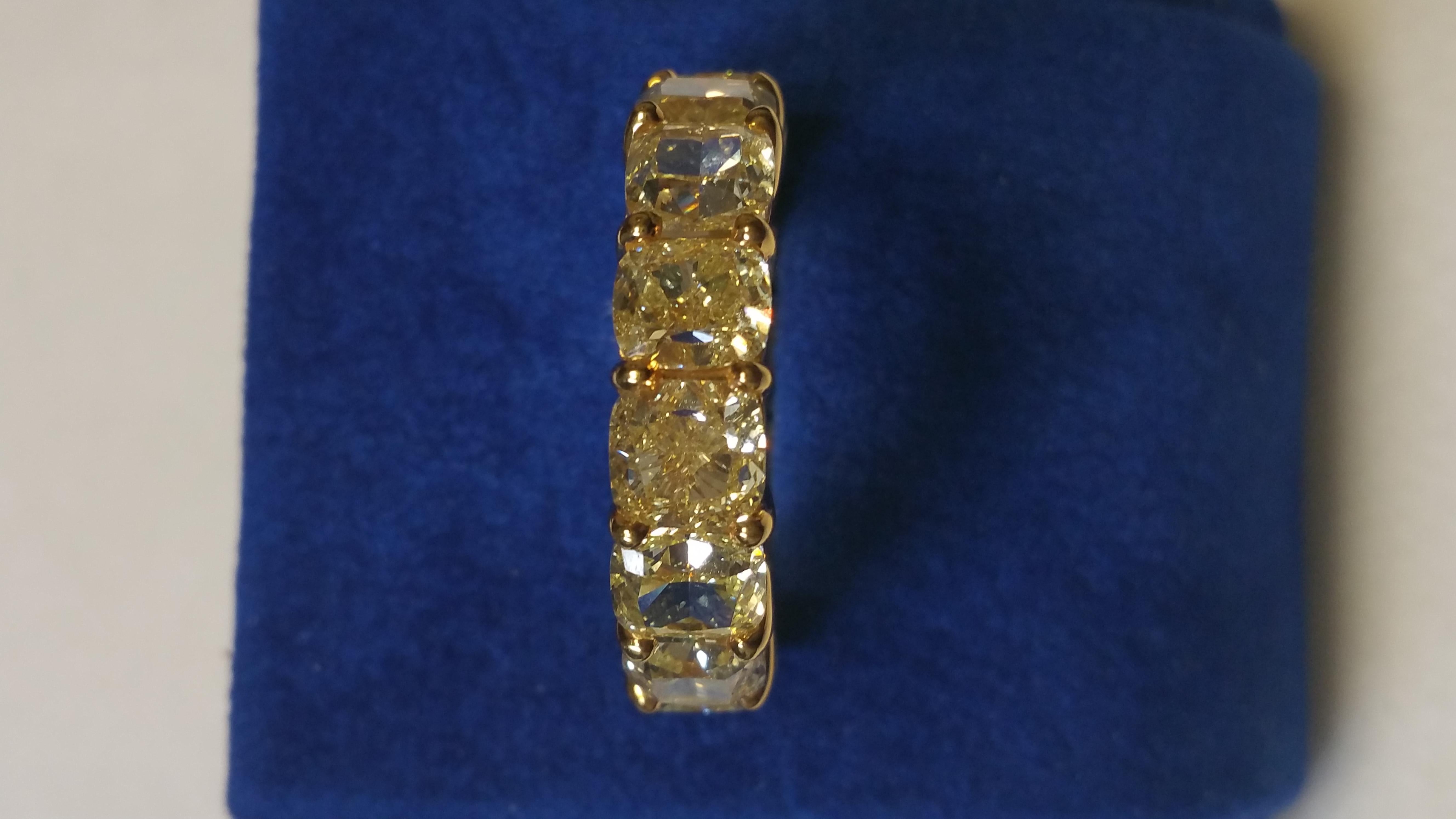 This Fancy Intense Yellow Cushion Cut Eternity band is a pleasure to wear every day and contains 11.60  carats of natural fancy  yellow diamonds of VVS2 - SI1 clarity in 18 karat yellow gold.  It is size 6 and is unusual in the marketplace  This