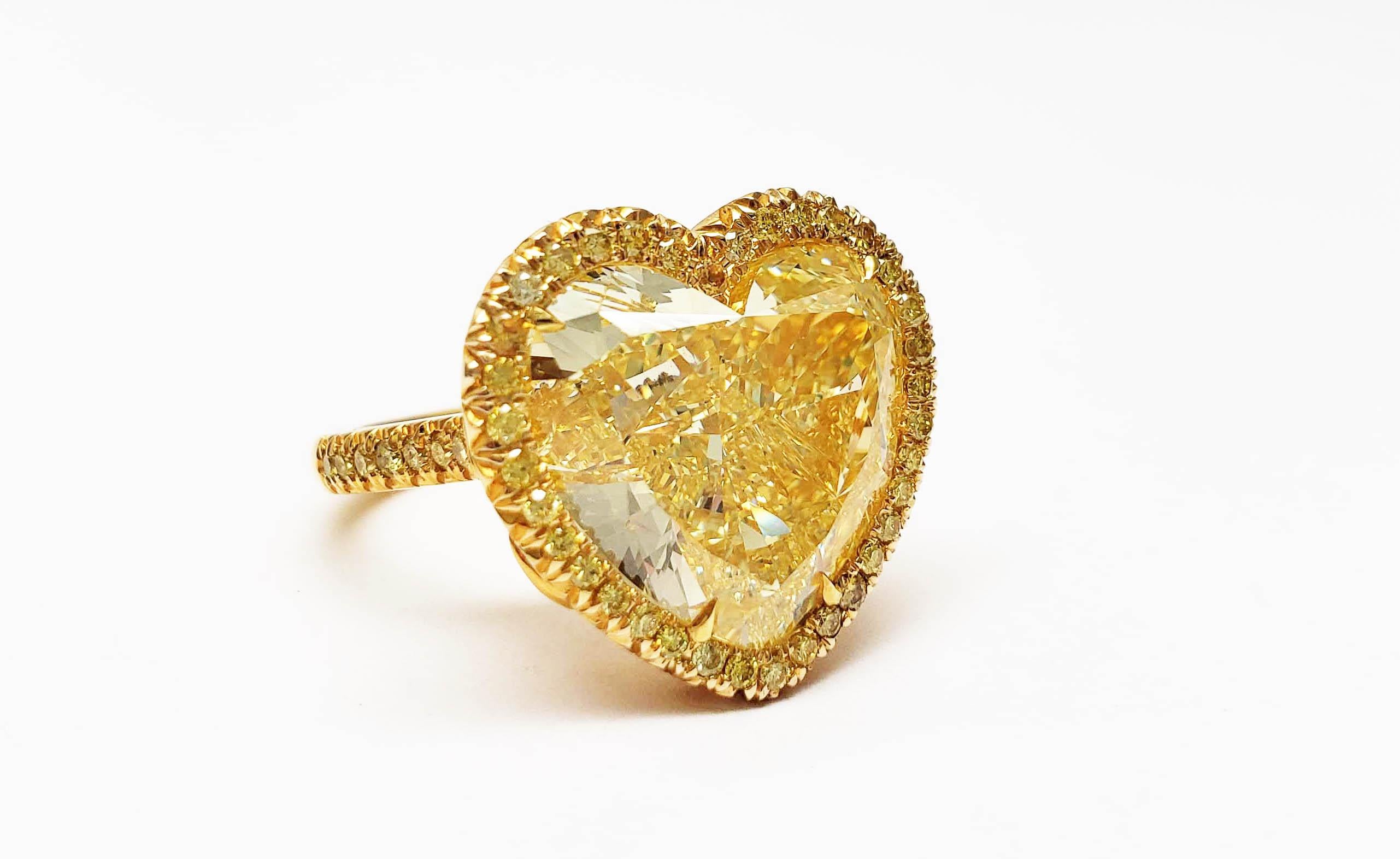 From SCARSELLI this ring has a Huge Sunny Heart.  This 12.20 carat Fancy Intense Yellow Heart shape diamond (GIA graded VS1 ) is  surrounded by Yellow diamonds in an 18 karat Yellow gold hand made ring. The presentation of this diamond is large and