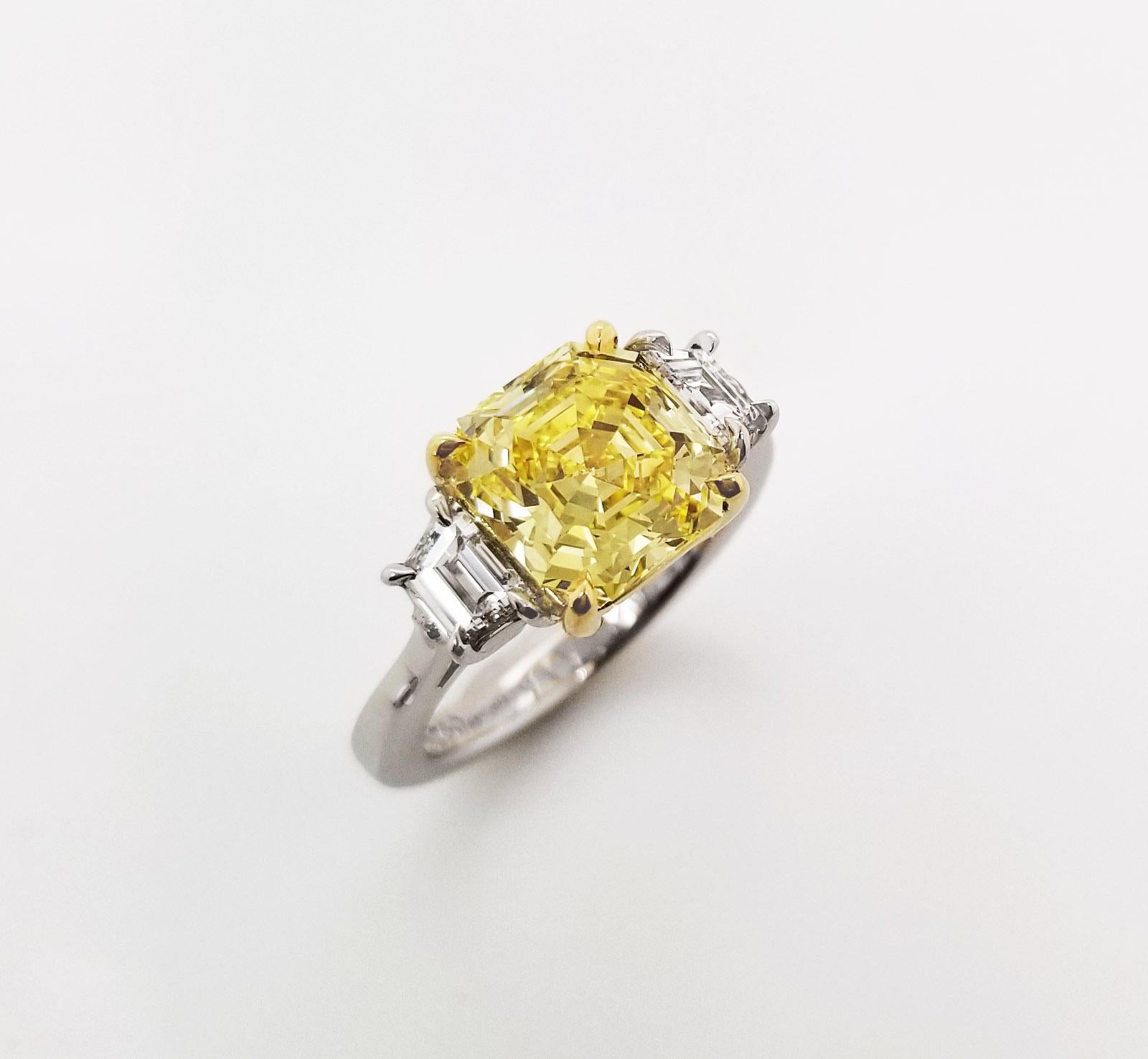 From SCARSELLI, this beautiful statement ring features a 3 carat Fancy Vivid Yellow Emerald Cut Diamond flanked by a couple of E color VS clarity trapezoid cut white diamonds totaling 0.72 carats (see GIA certificate picture for more detailed center