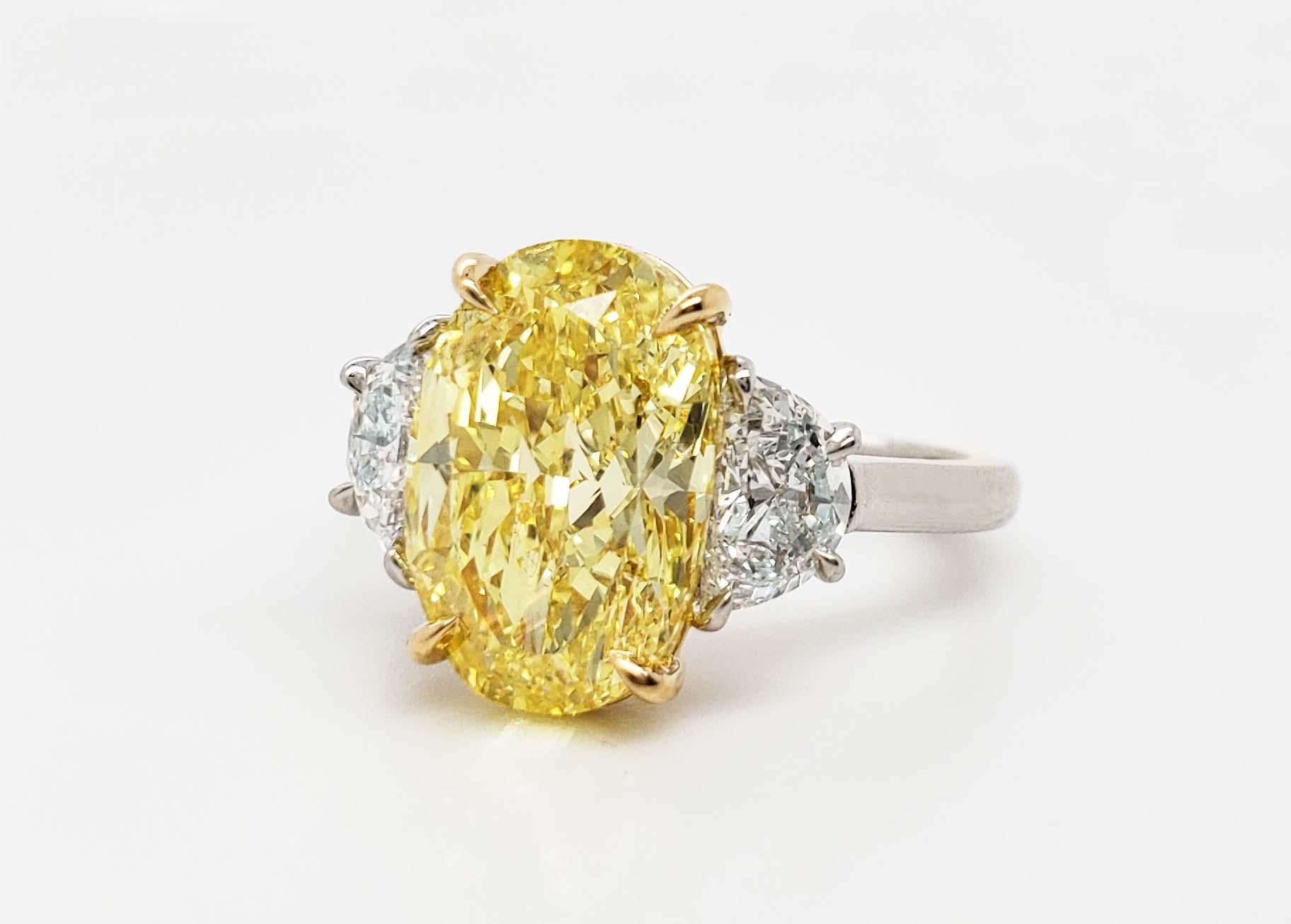From SCARSELLI, this spectacular 4.70 carat Fancy Vivid Yellow Oval Cut Diamond is GIA certified (see picture of certificate for detailed stone information) and classically set on a hand-made 18k gold & platinum with a pair of white half moon
