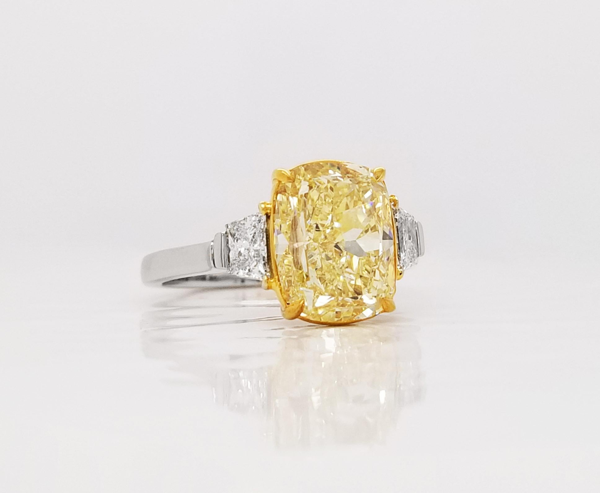 2022 is the Year of the yellow color Cushion Cut Engagement Ring  and this ring is perfection with a 4.01 carat Fancy Yellow Cushion Cut Diamond of  VVS2 clarity, GIA Certified,  with .47 carats in F Color side trapezoid cut diamonds in Platinum and